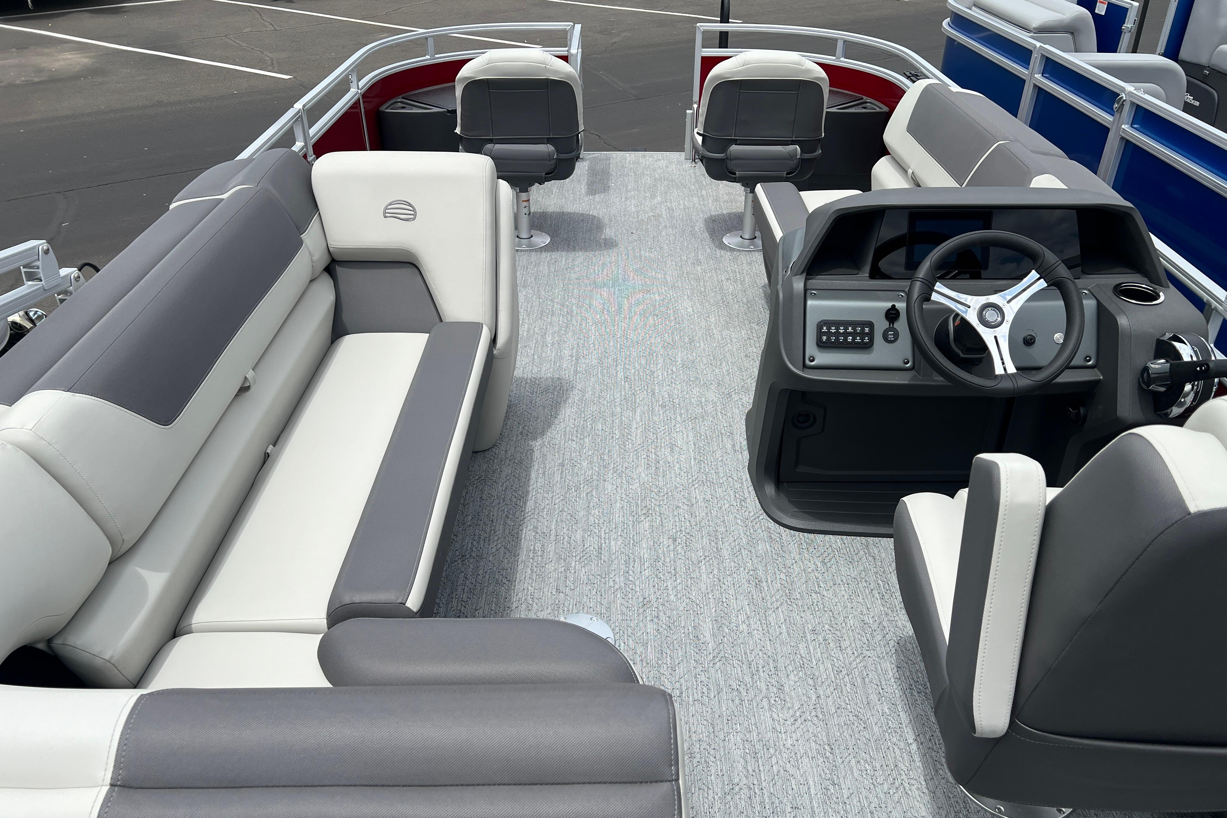 Interior view of 2026 Sun Tracker Fishin' Barge 22 DLX pontoon boat with seating and helm.