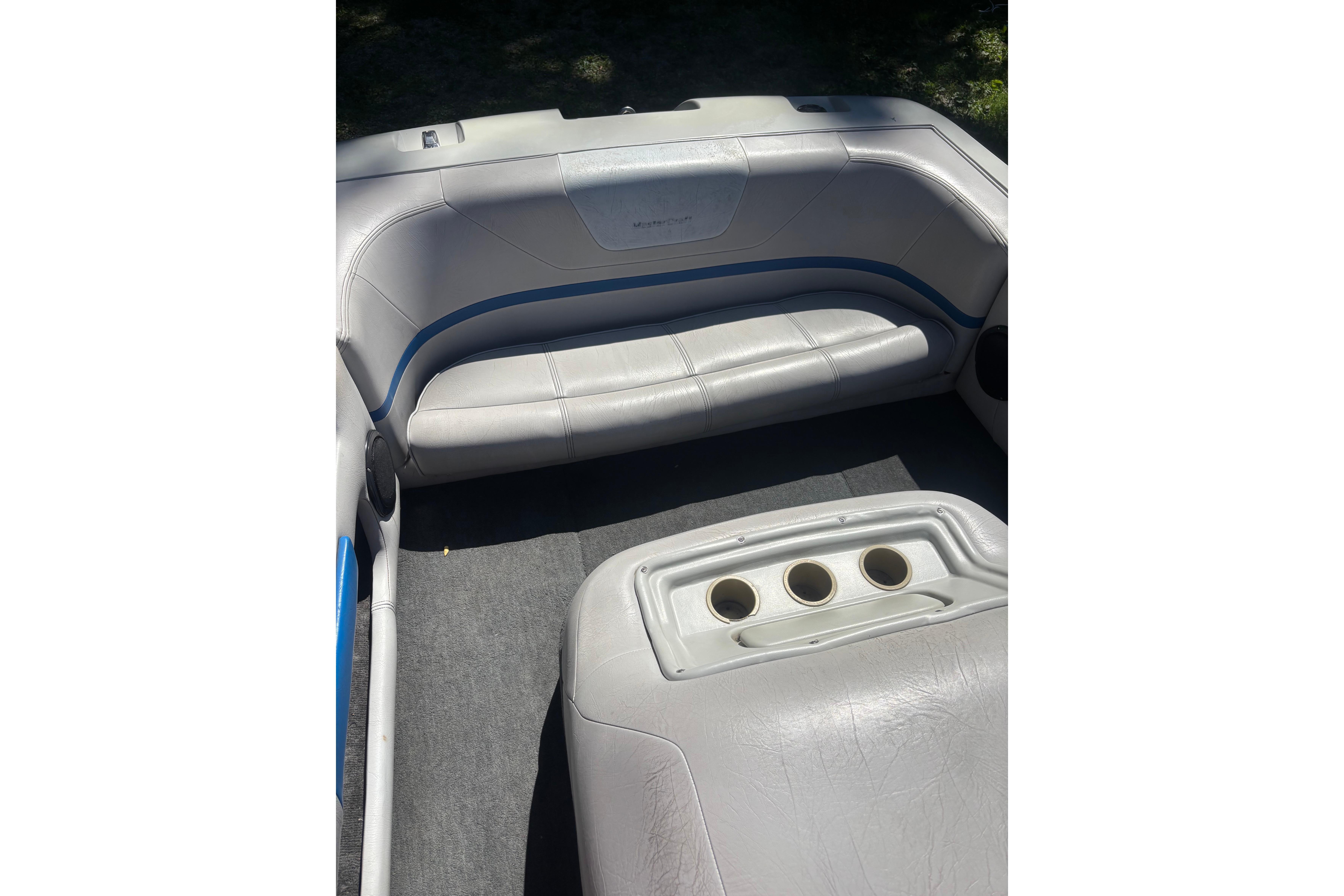 Interior of a 1990 MasterCraft ProStar 190 boat with gray seating and cup holders.