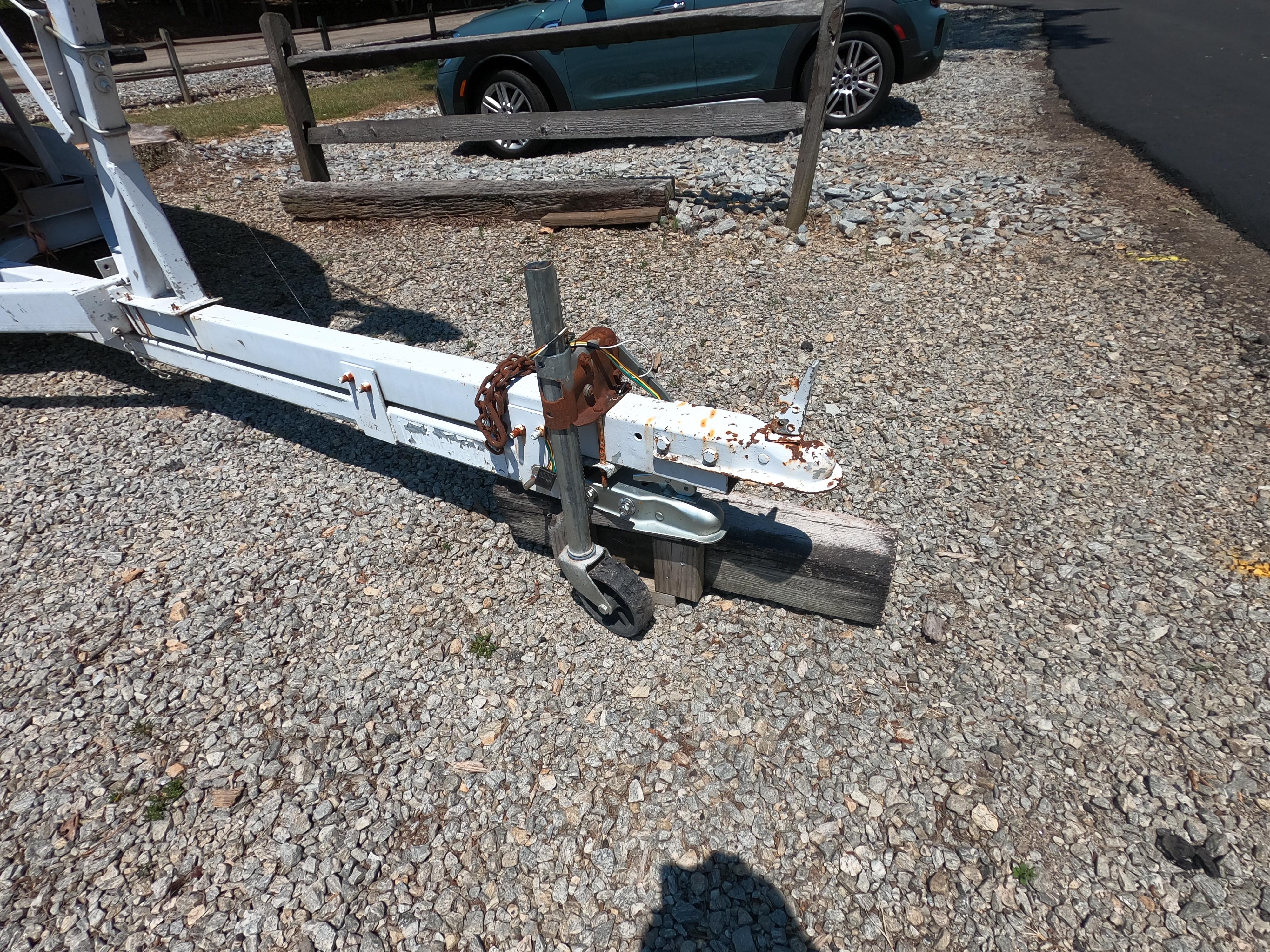 Trailer hitch of a 1980 Com-Pac 23 sailboat on gravel surface.