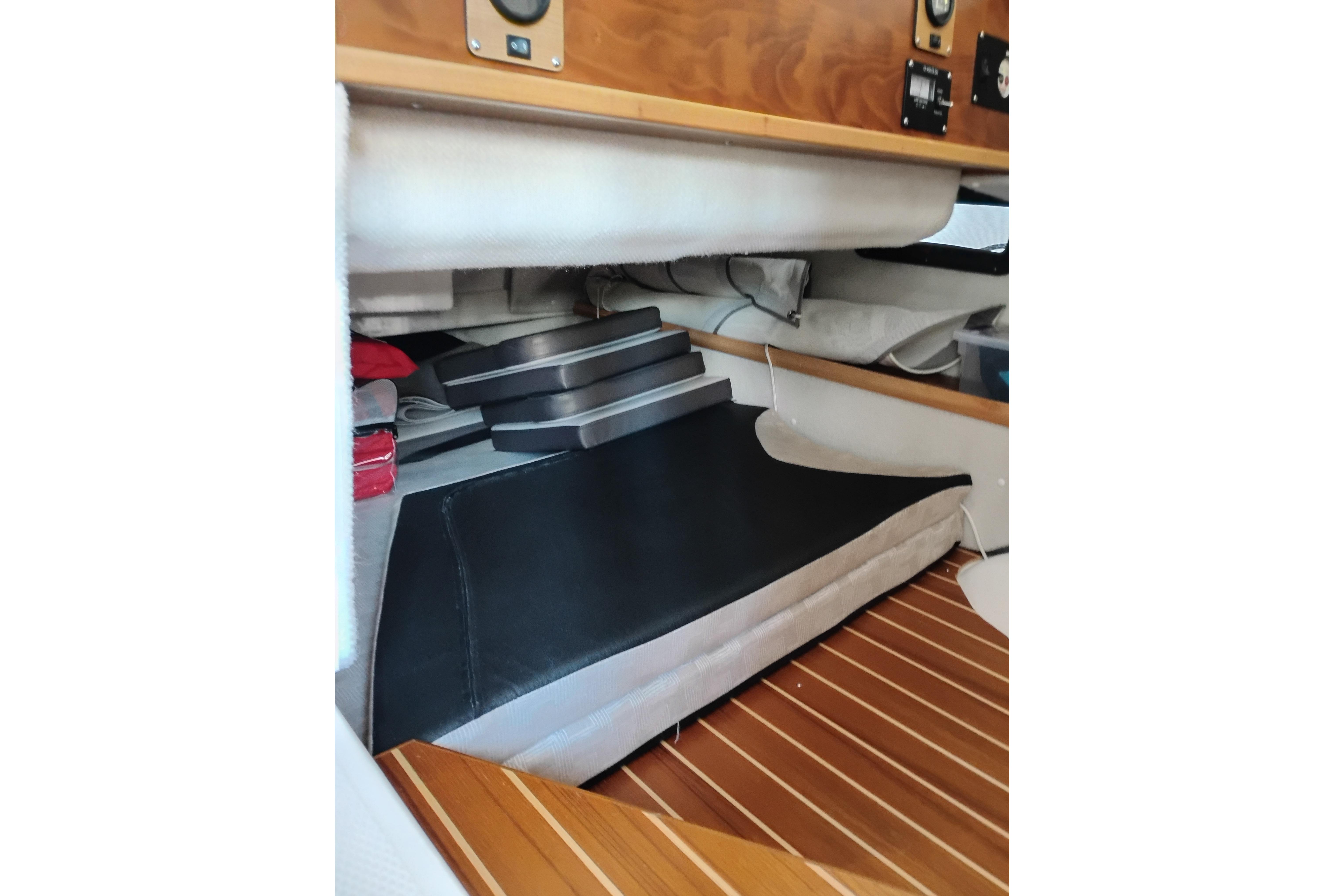 Interior view of 2022 Cutwater C-32 Coupe boat with wooden flooring and storage compartments.