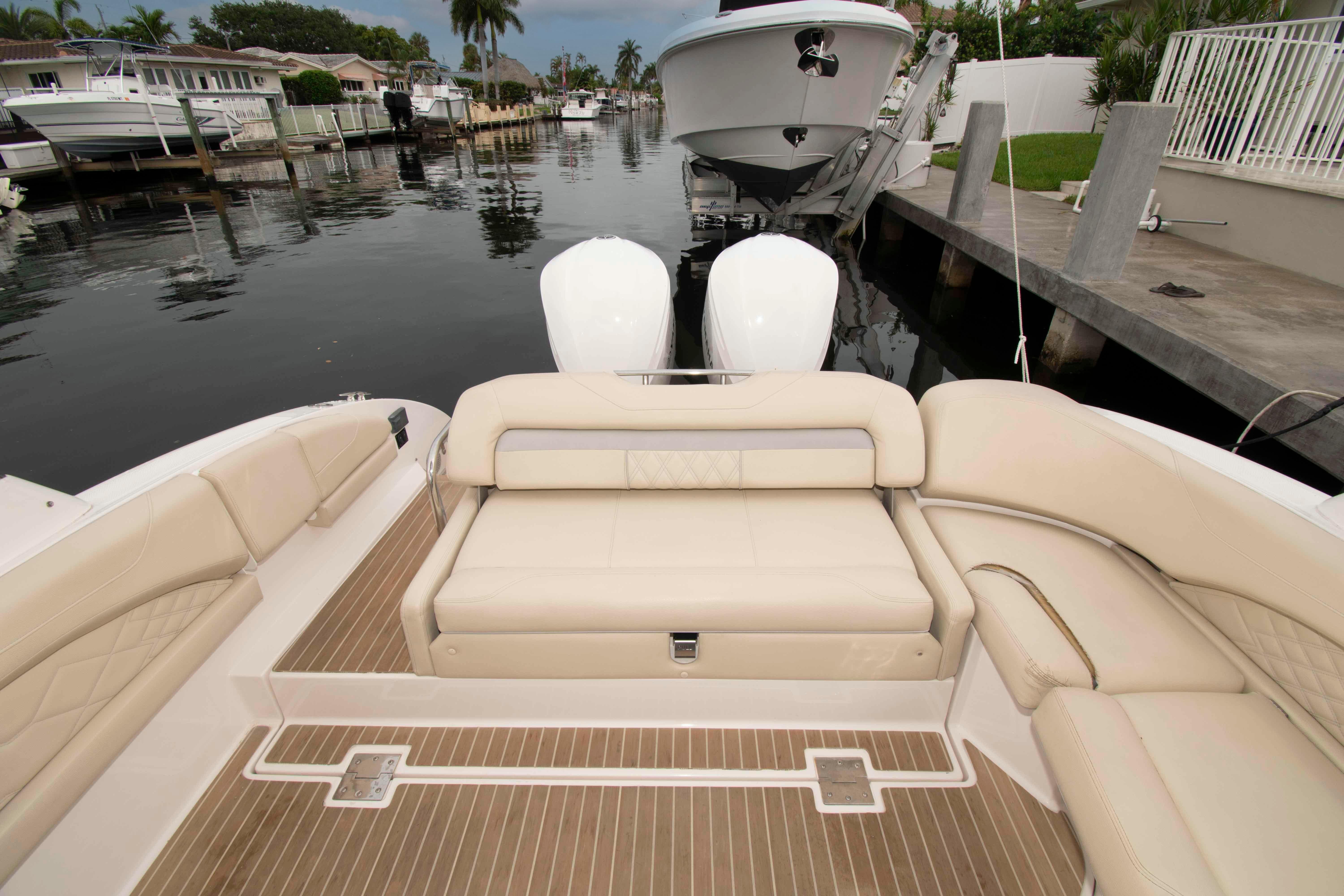 2019 Regal 33 OBX boat interior with beige seating and wooden deck, docked in a canal.