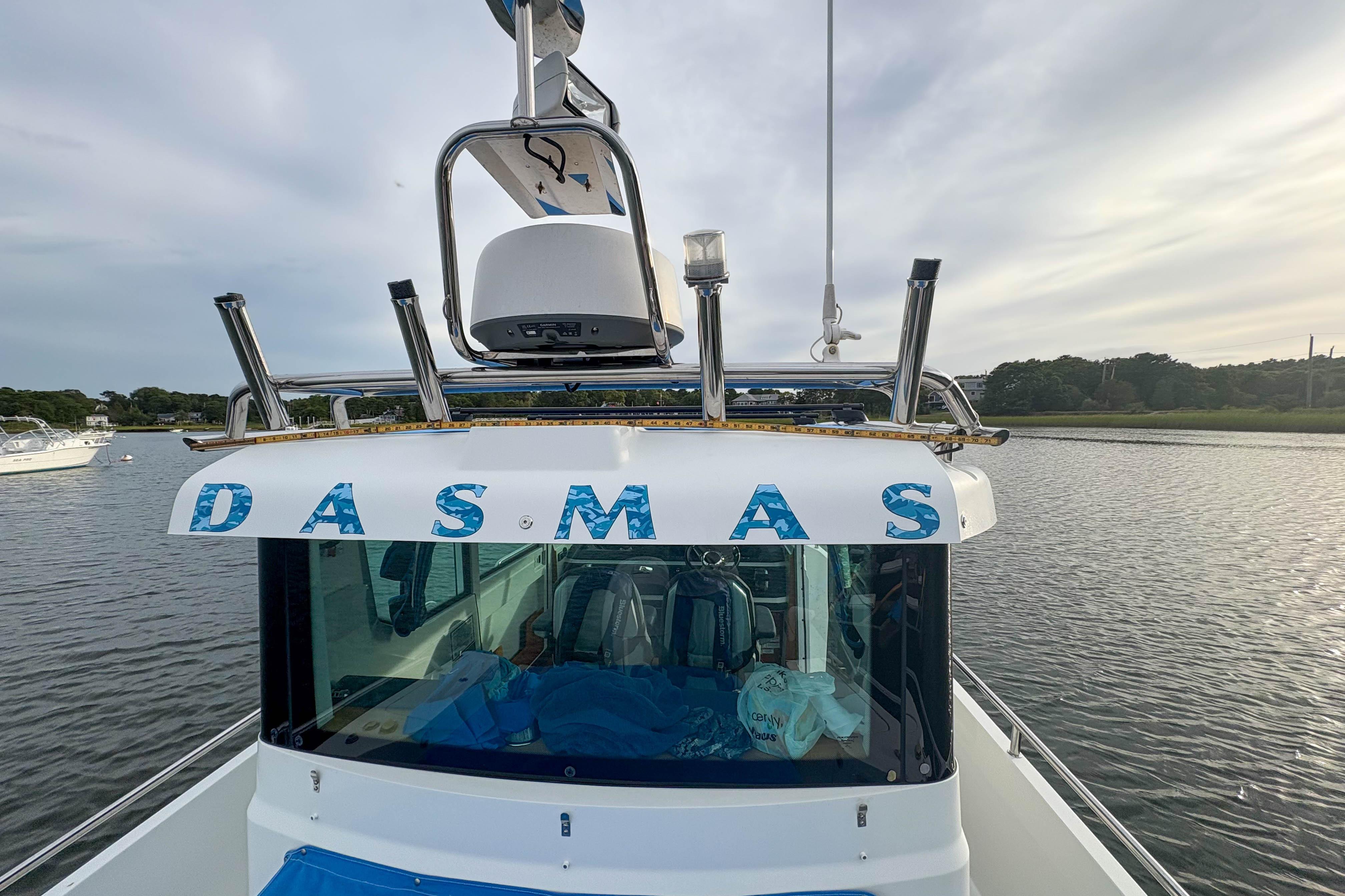 Axopar 28 Cabin 2020 boat named "DASMAS" on calm water with scenic background.
