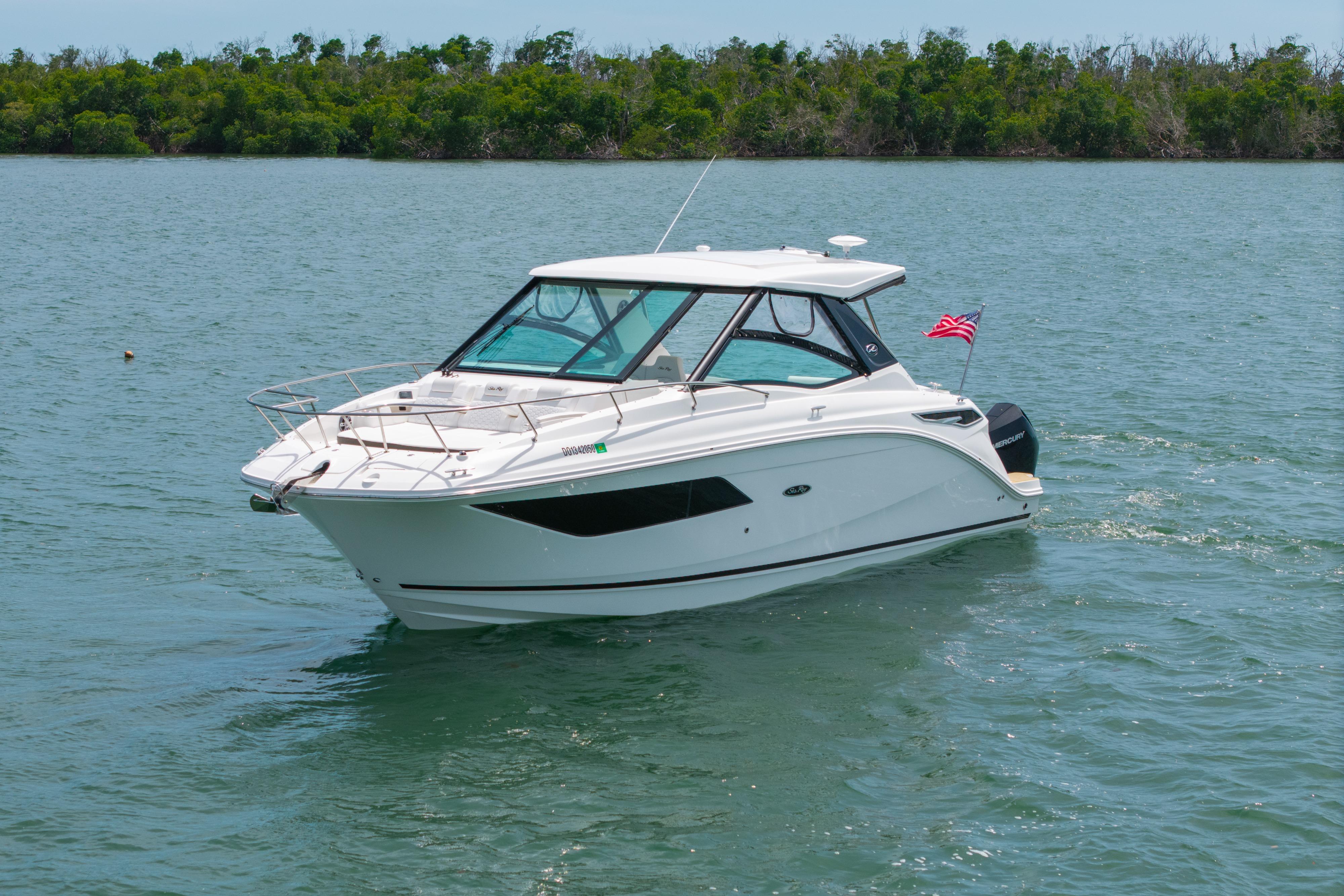 2024 Sea Ray Sundancer 320 Outboard cruising on a serene lake with lush greenery.