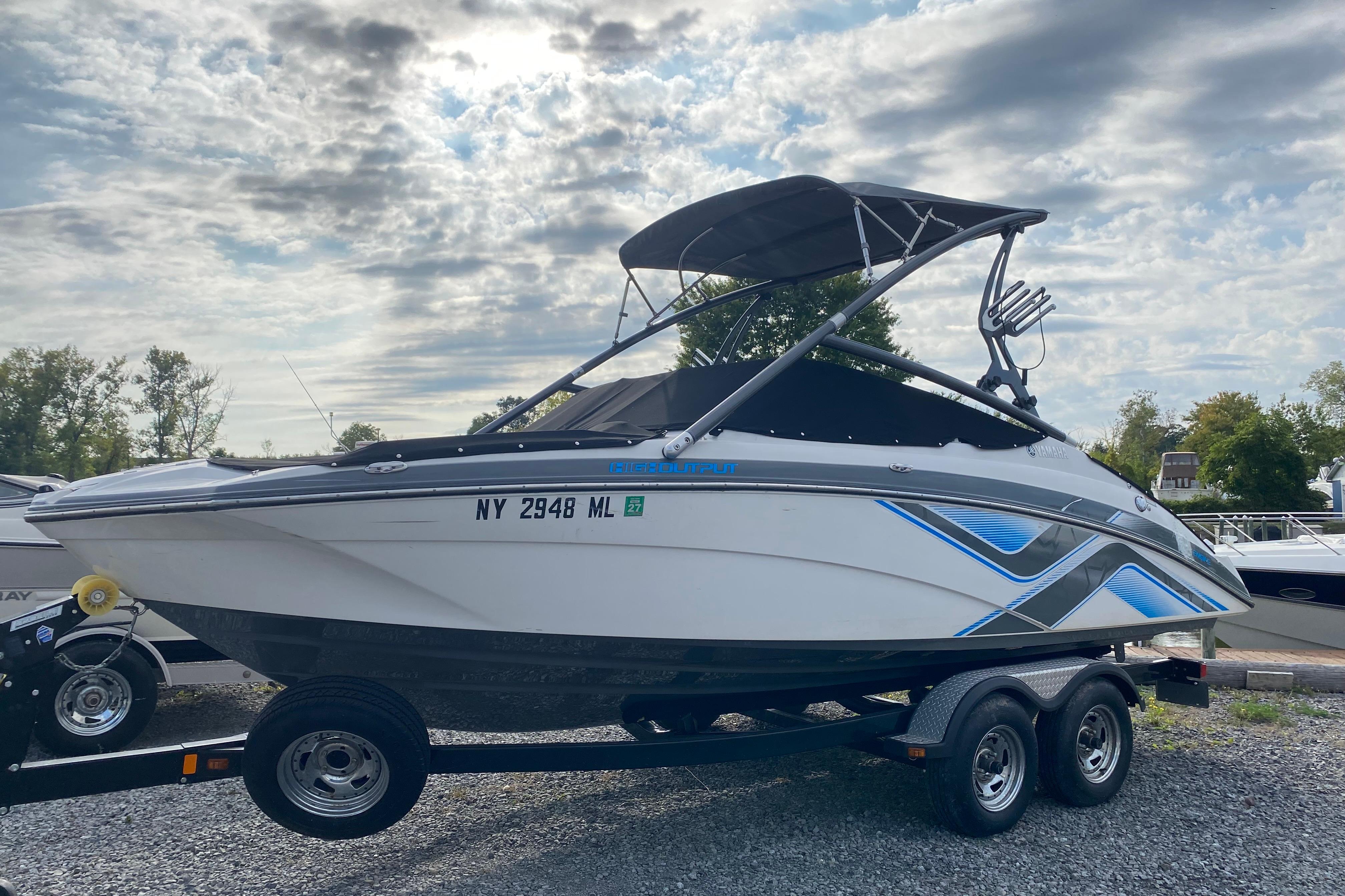 2015 Yamaha Boats 212X on trailer under cloudy sky, side view.