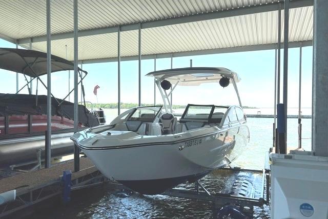 2021 Yamaha Boats 275SD docked under a covered marina, showcasing sleek design and modern features.