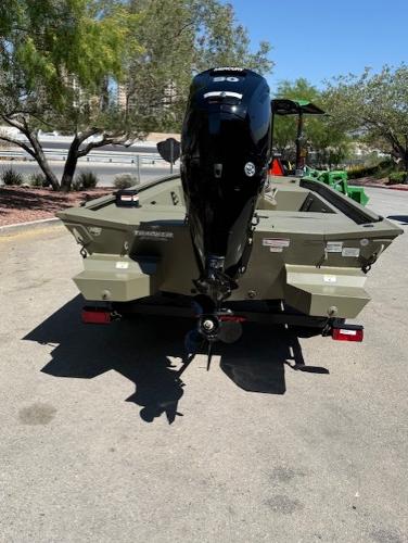 2025 Tracker Grizzly 1860 CC boat with powerful outboard motor, parked outdoors.