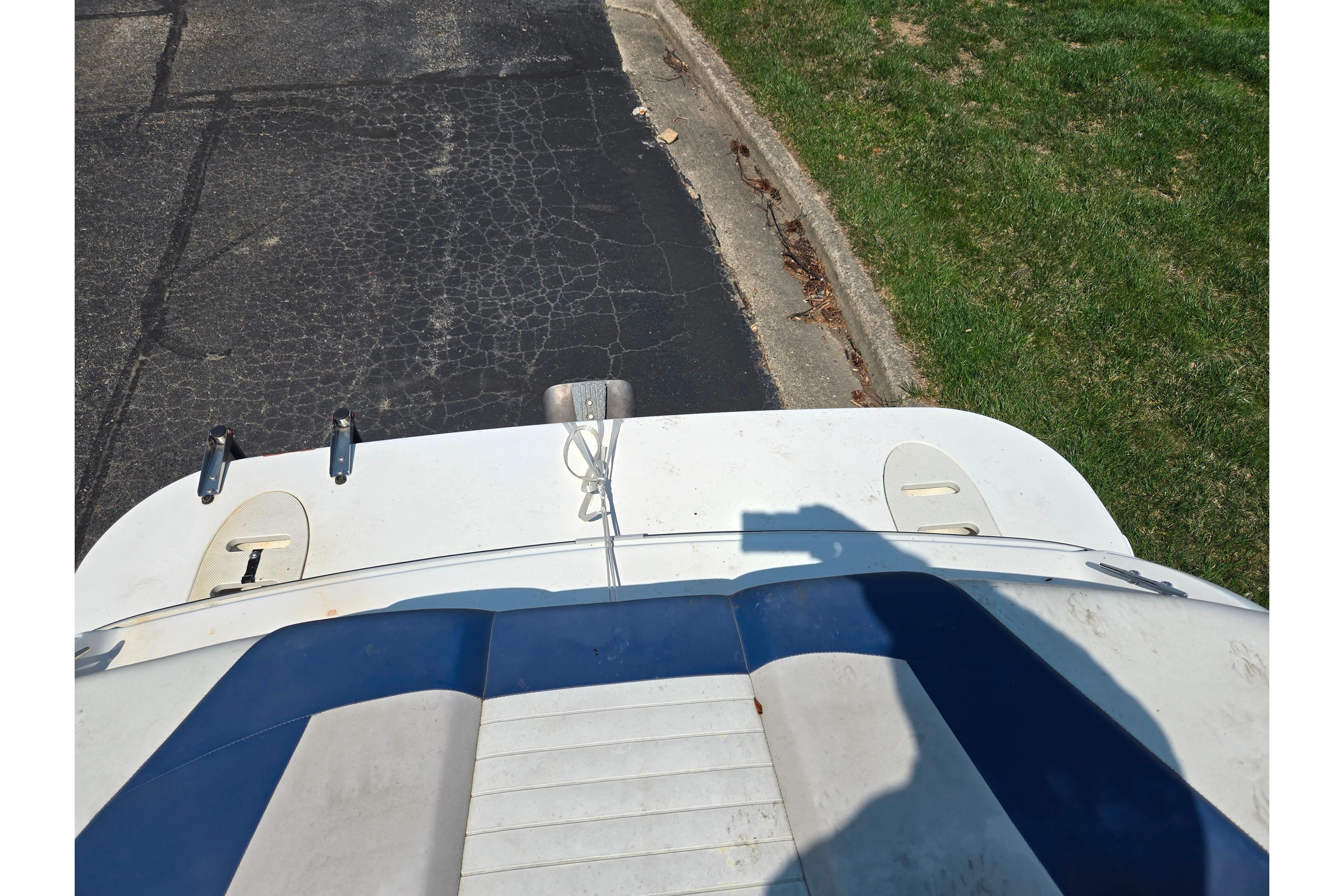 2007 Glastron GT 185 boat stern view on pavement and grass.