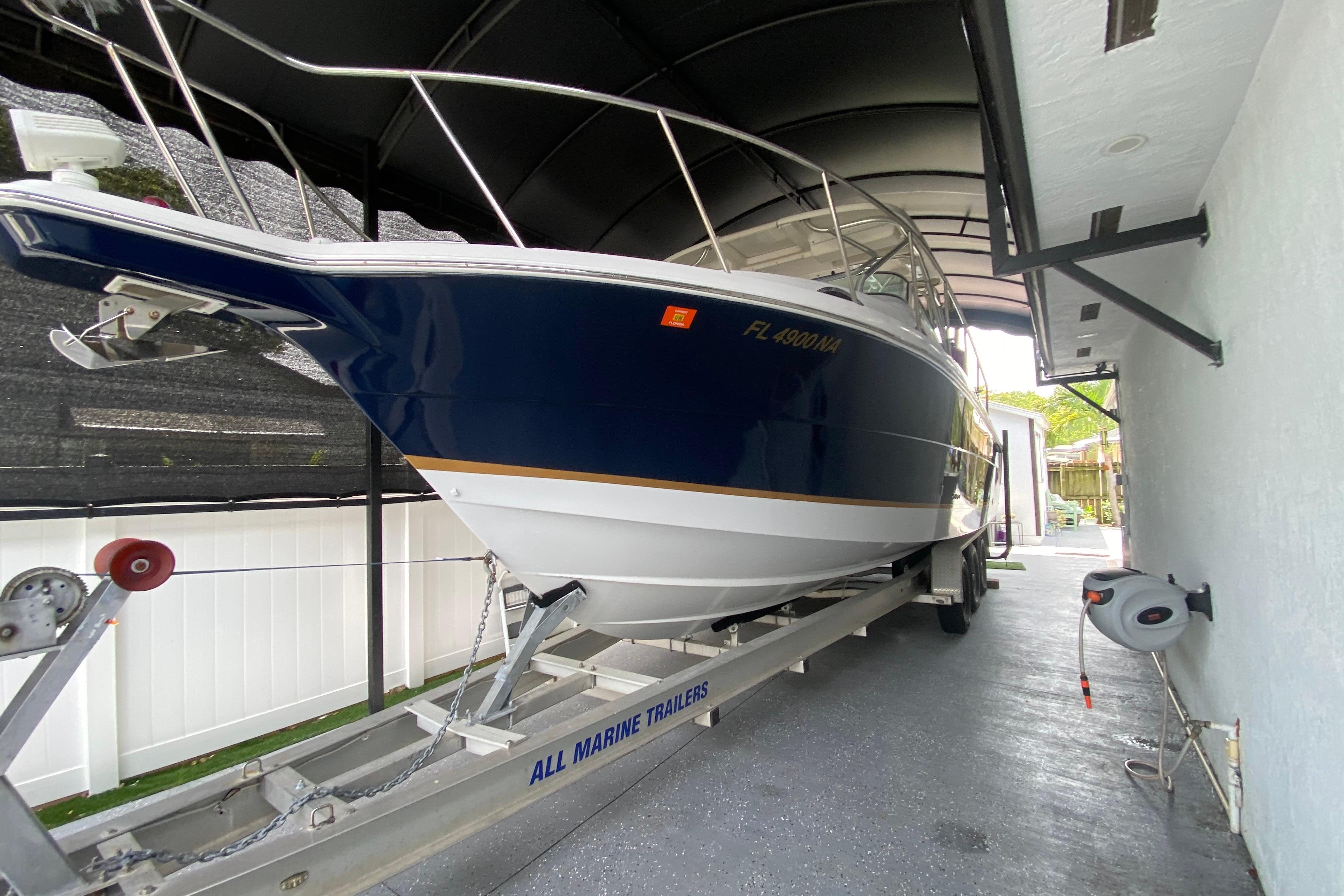 2005 Wellcraft 290 Coastal boat on trailer in covered storage area.
