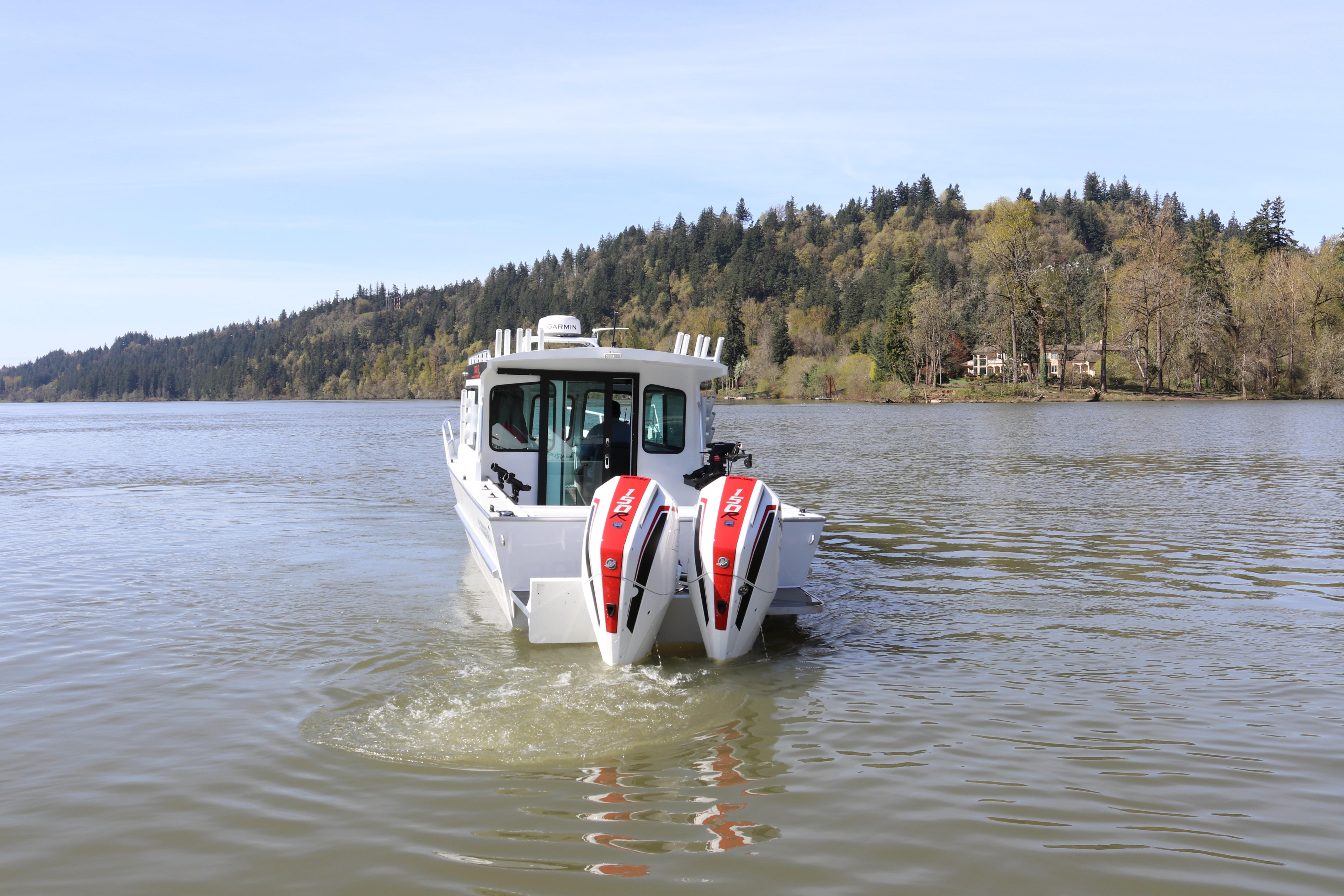 2026 Alumaweld Horizon 26 boat cruising on a scenic lake with forested hills.