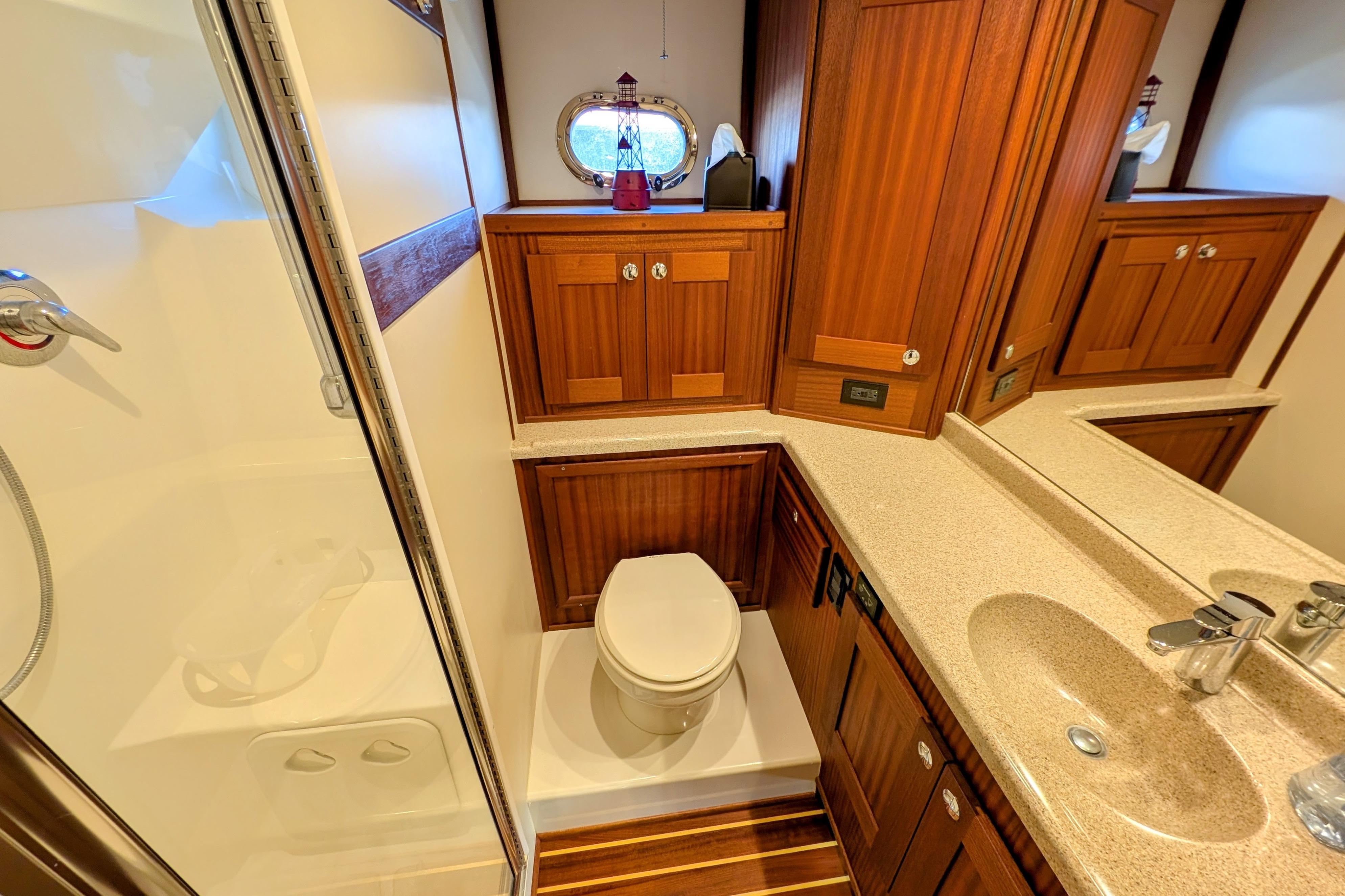 Luxurious bathroom in 2015 American Tug 435 yacht with wooden cabinetry and modern fixtures.