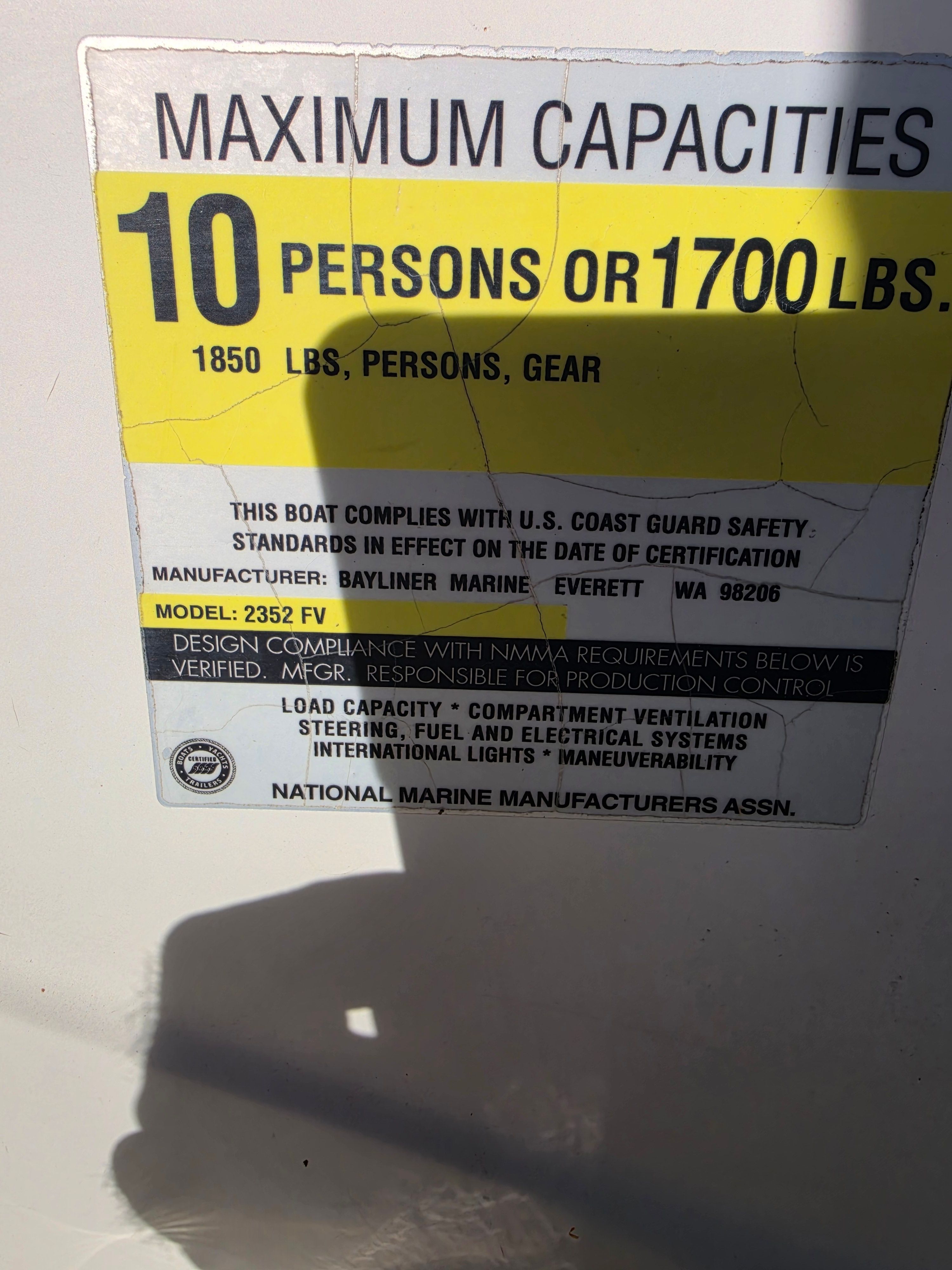 Sign shows maximum capacity of 10 persons or 1700 pounds for Bayliner 2352 Trophy Walkaround.