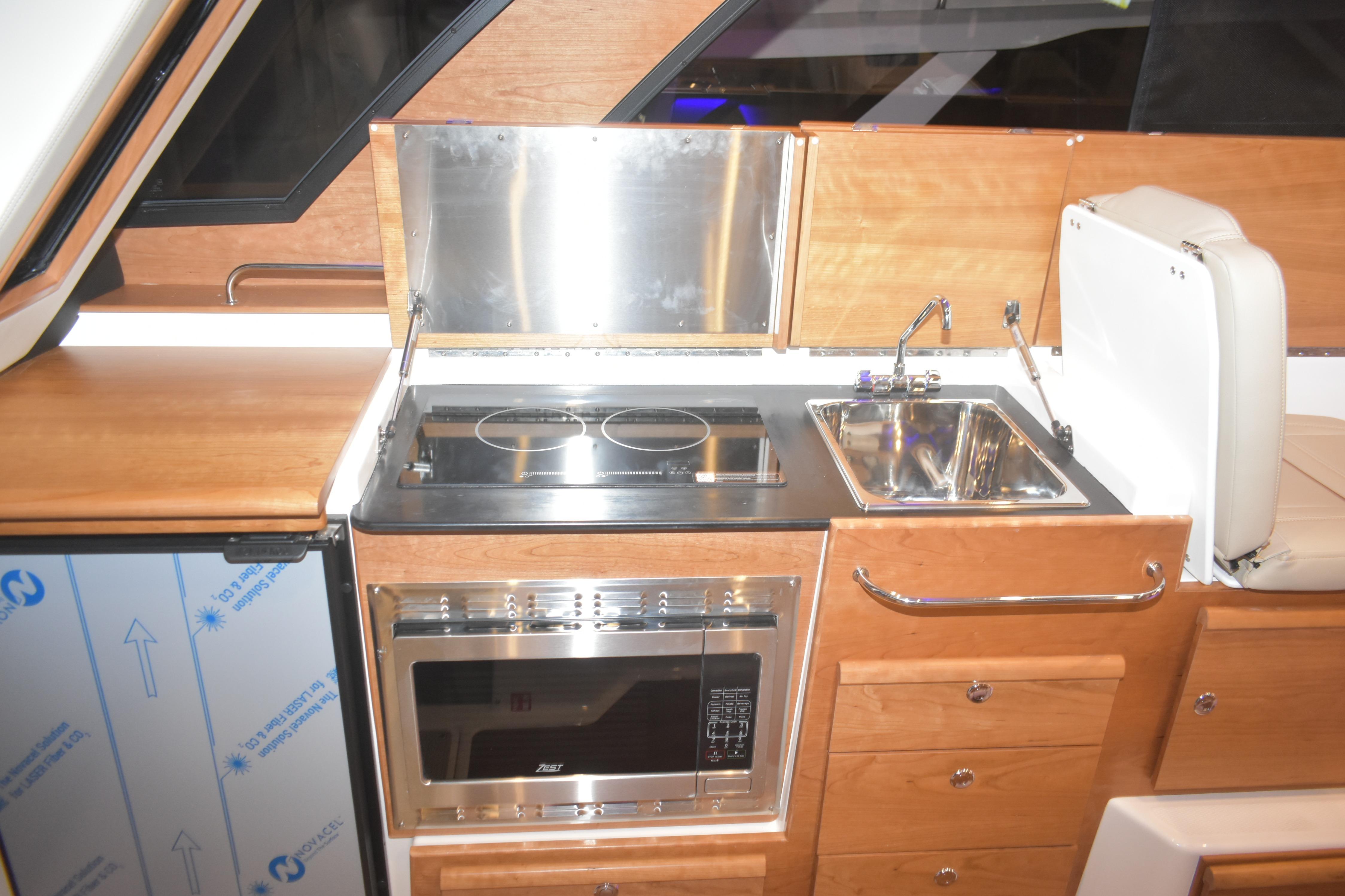 2026 Cutwater C-32 CB yacht kitchen with stove, oven, and sink.