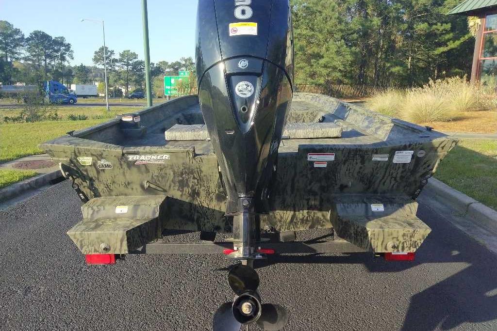 2026 Tracker Grizzly 2072 CC boat with outboard motor, parked outdoors.