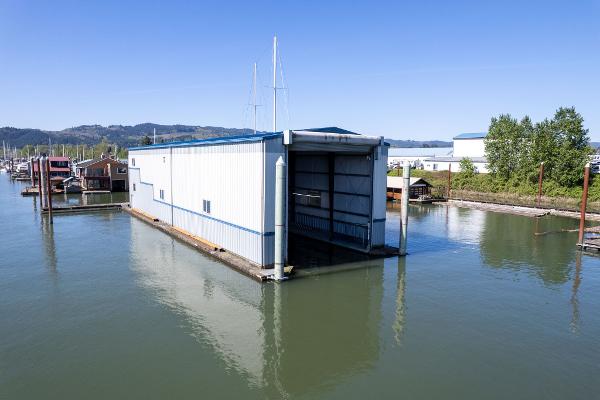 Custom 1985 Larson Boathouse floating on calm water under clear blue sky.