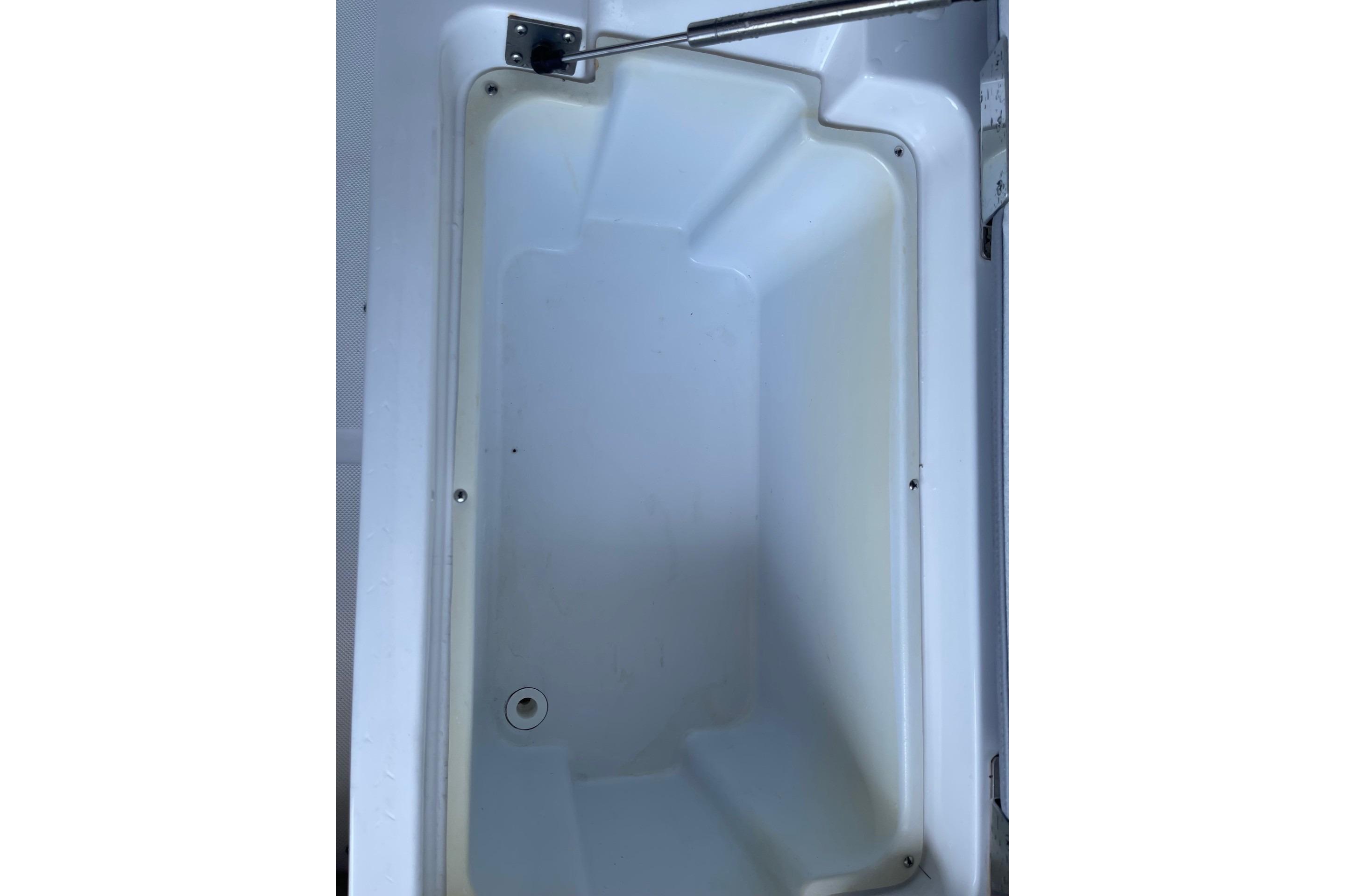 Storage compartment of a 2022 Cobalt R8 Outboard boat, featuring a drain plug.