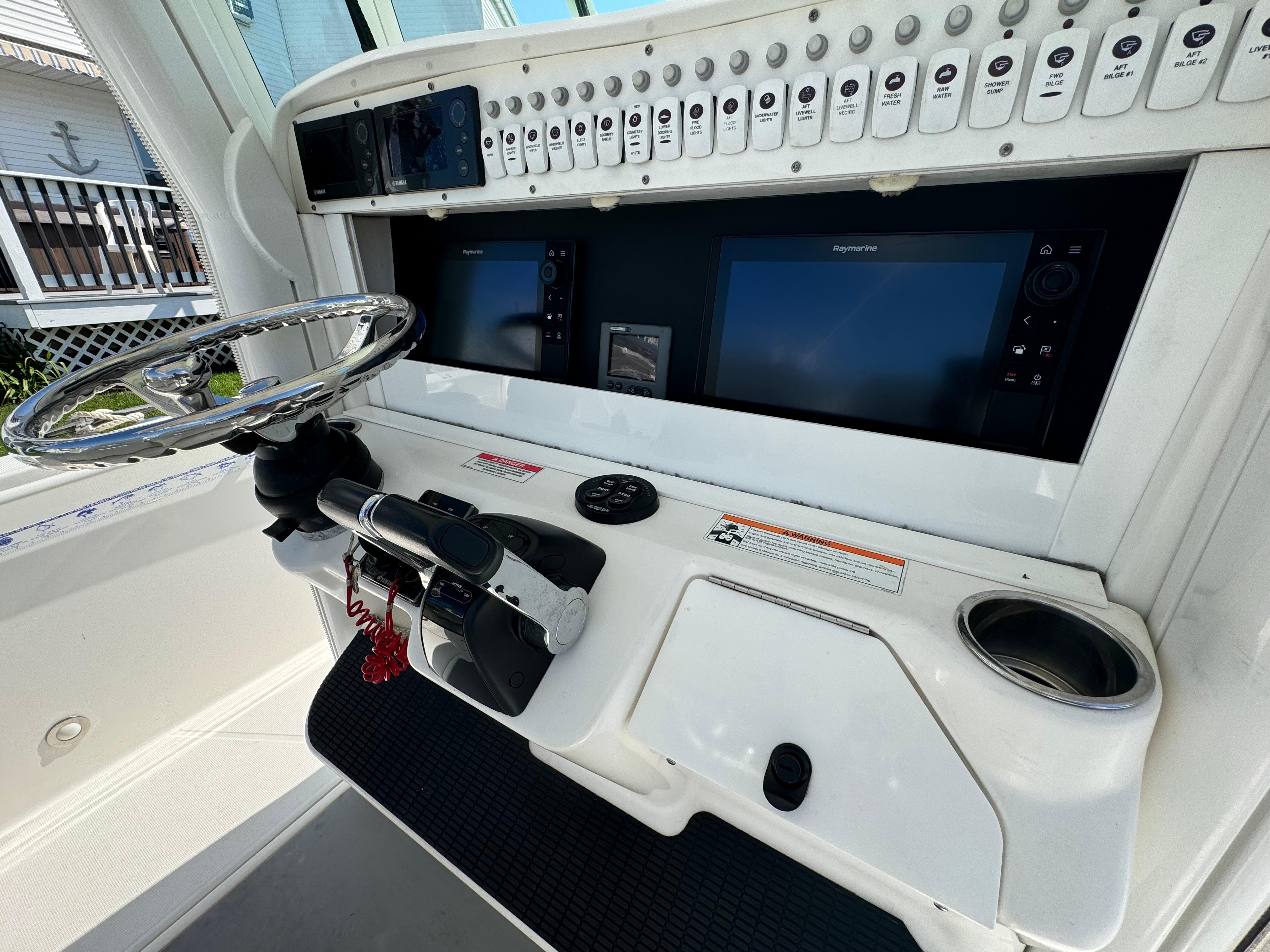 2011 Everglades 325 Center Console dashboard with steering wheel and navigation screens.