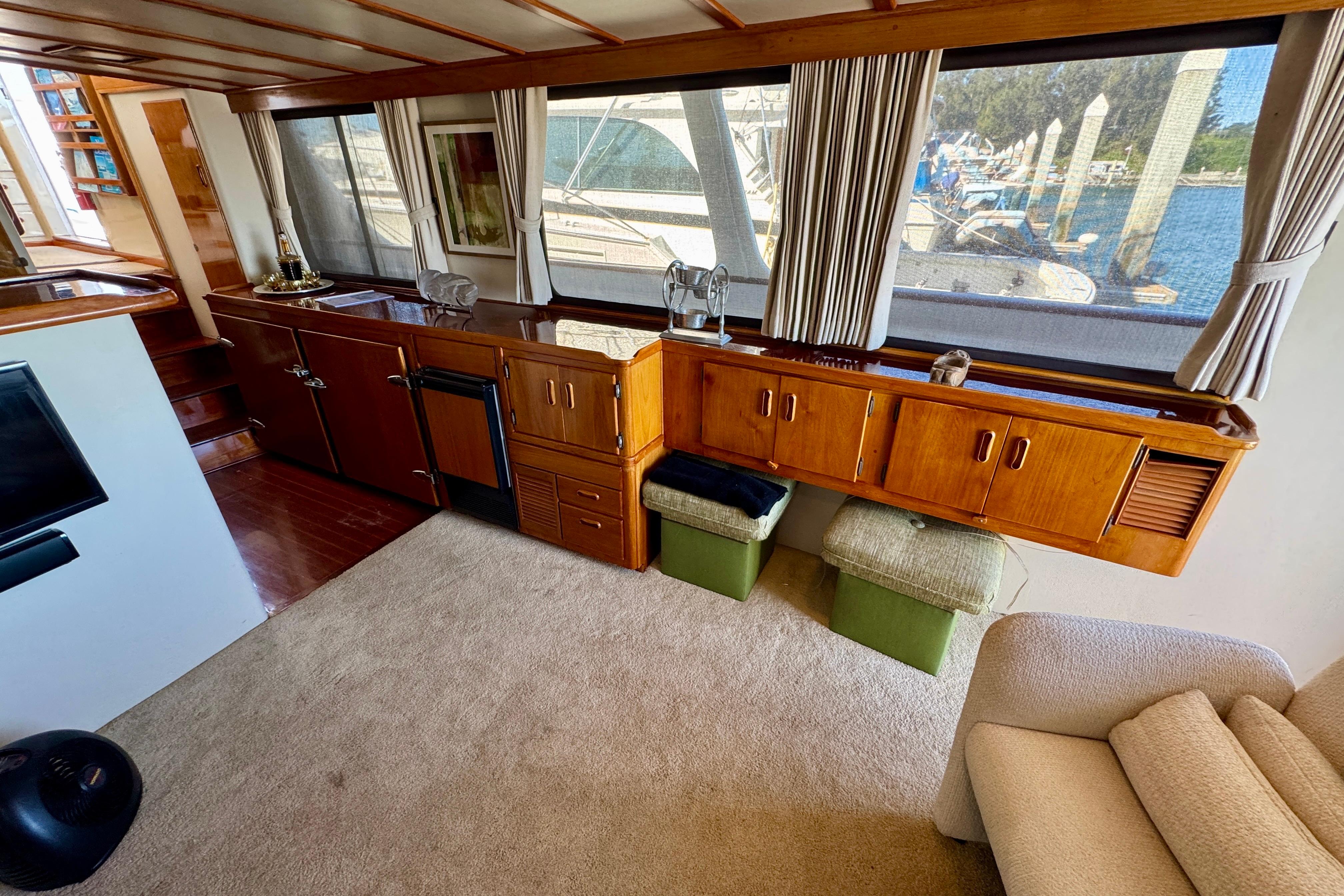 Interior of a 1958 Blanchard Pilothouse boat with wooden cabinetry and large windows.