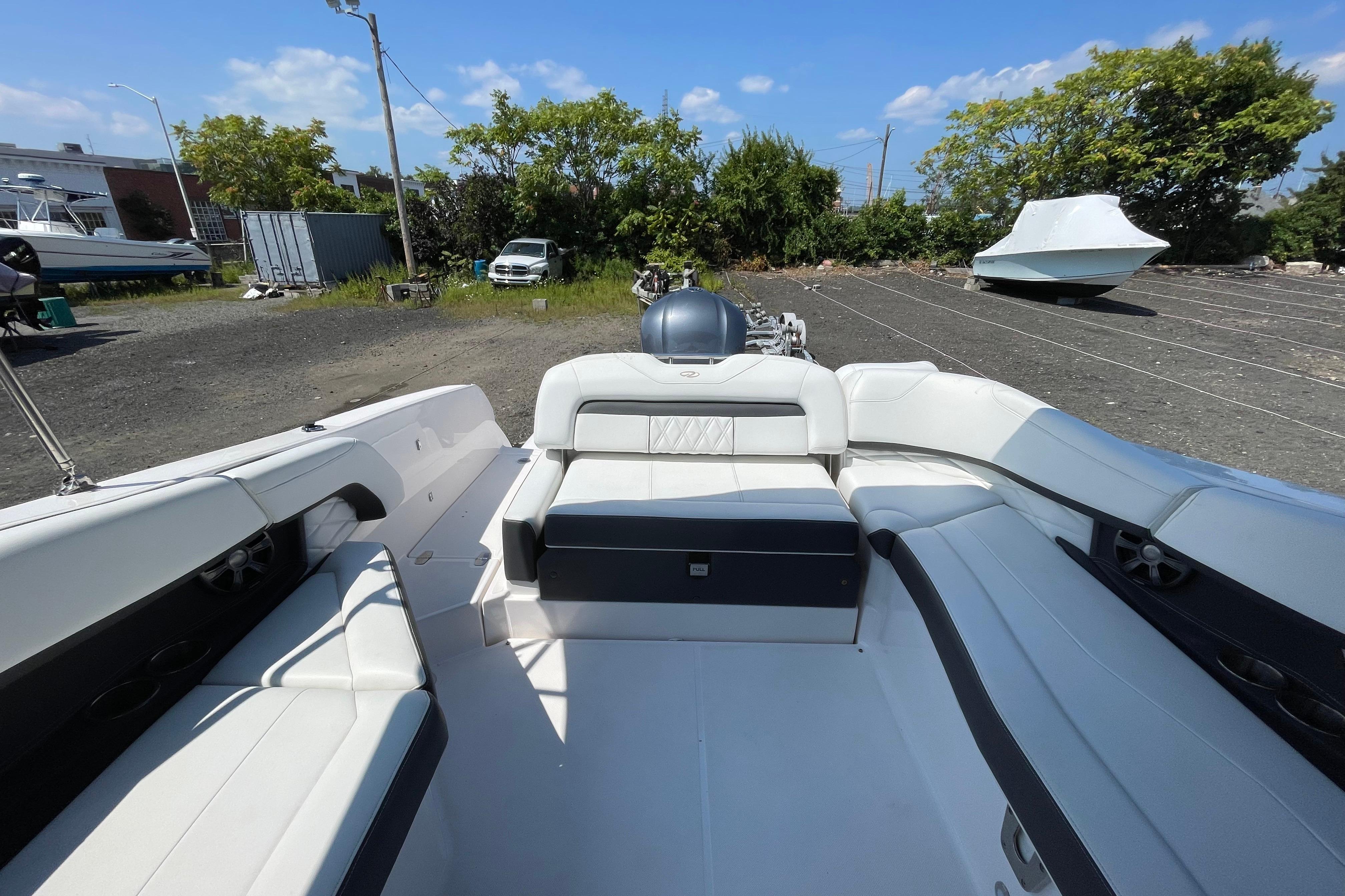2018 Regal 26 OBX boat interior with white seating, parked outdoors under blue sky.