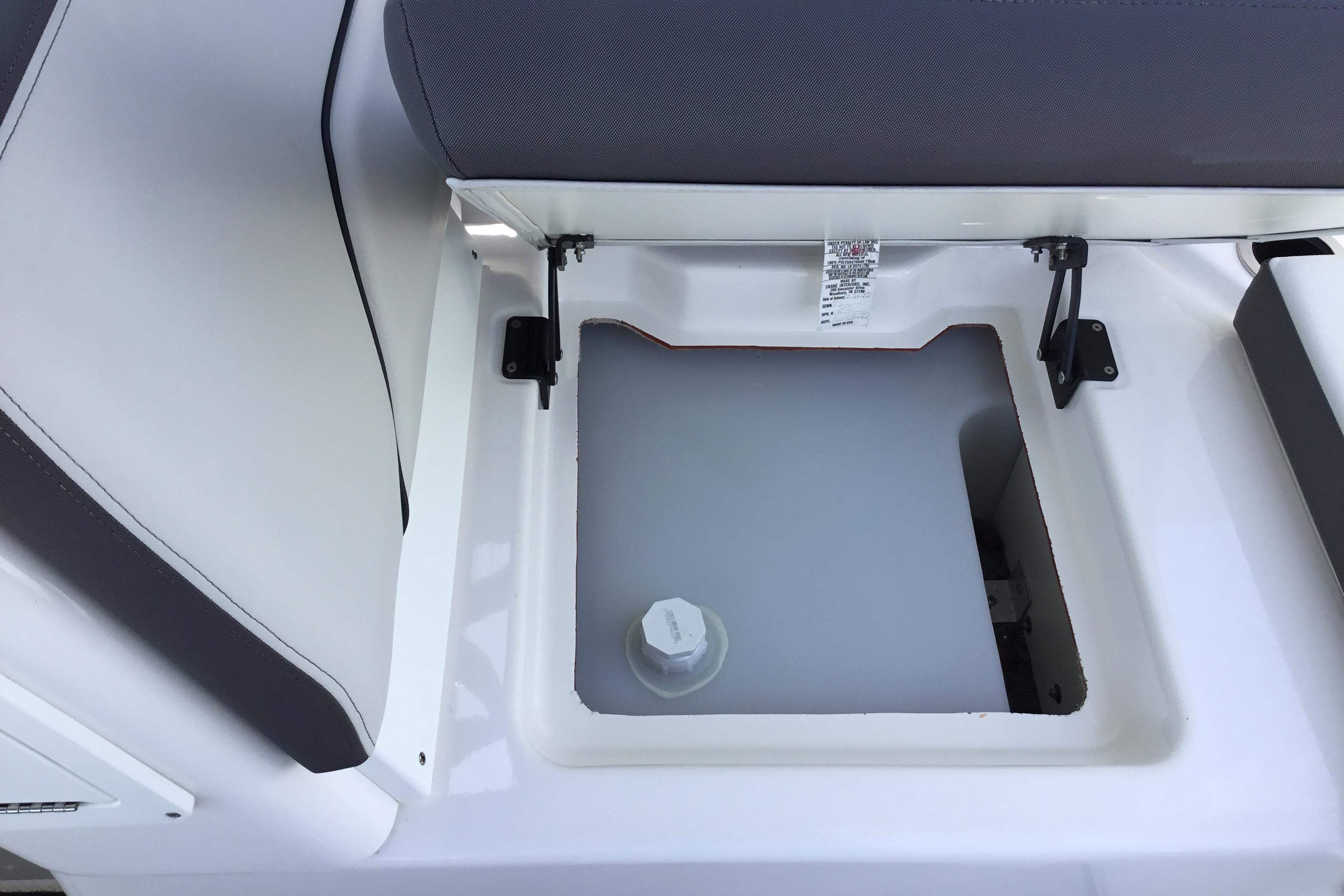 2023 Yamaha Boats 252XE storage compartment with open seat revealing interior space.
