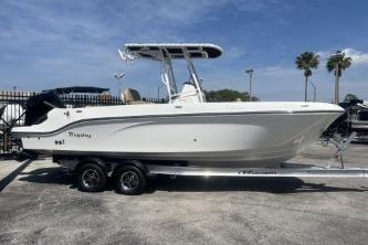 2023 Trophy T24 CC boat on trailer, parked outdoors under clear sky.