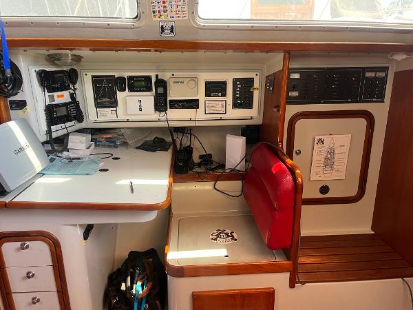 Navigation station of a 1996 Santa Cruz 52 yacht with control panels and seating.