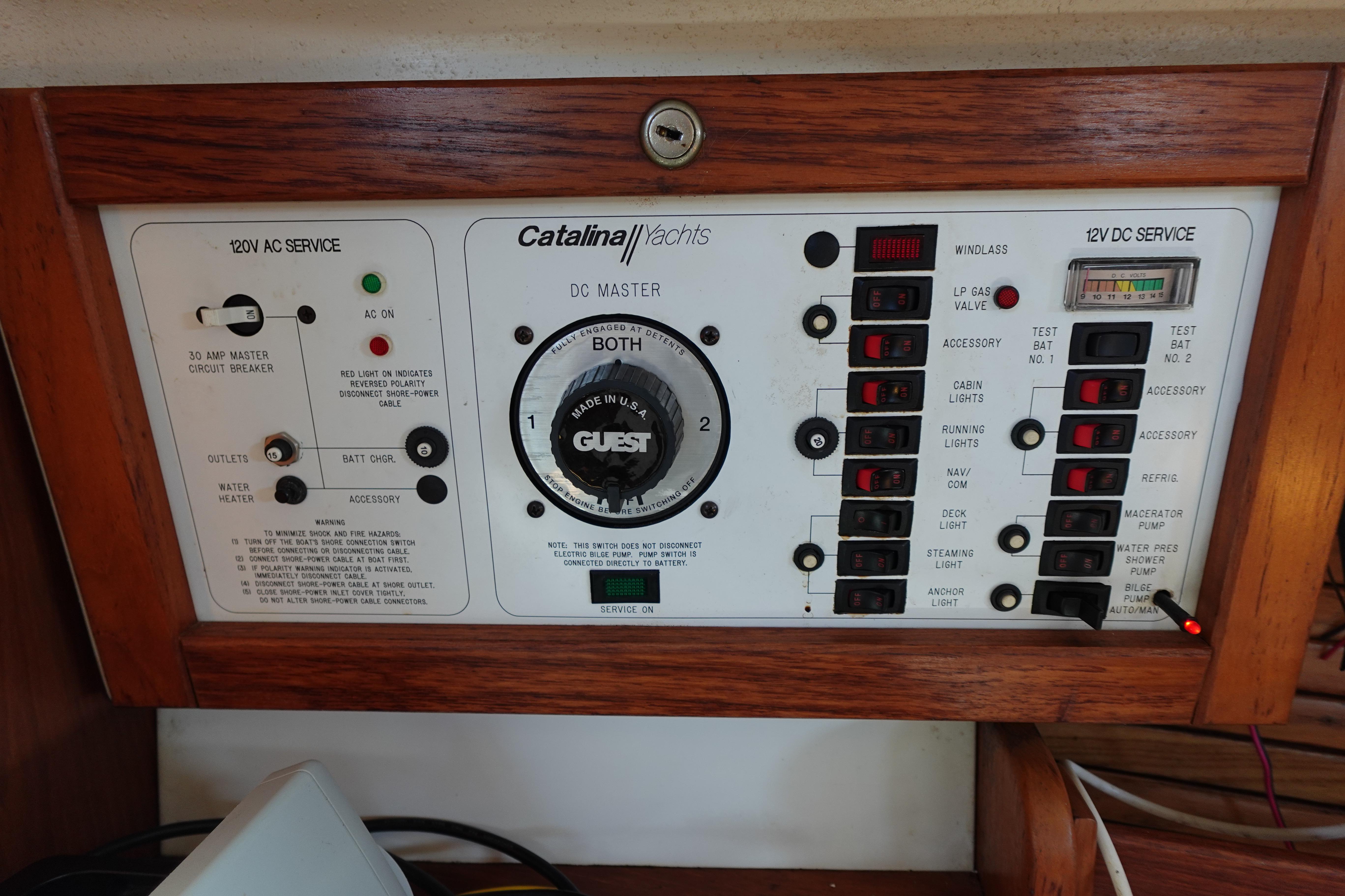 Control panel of a 1997 Catalina 28 yacht with various switches and indicators.