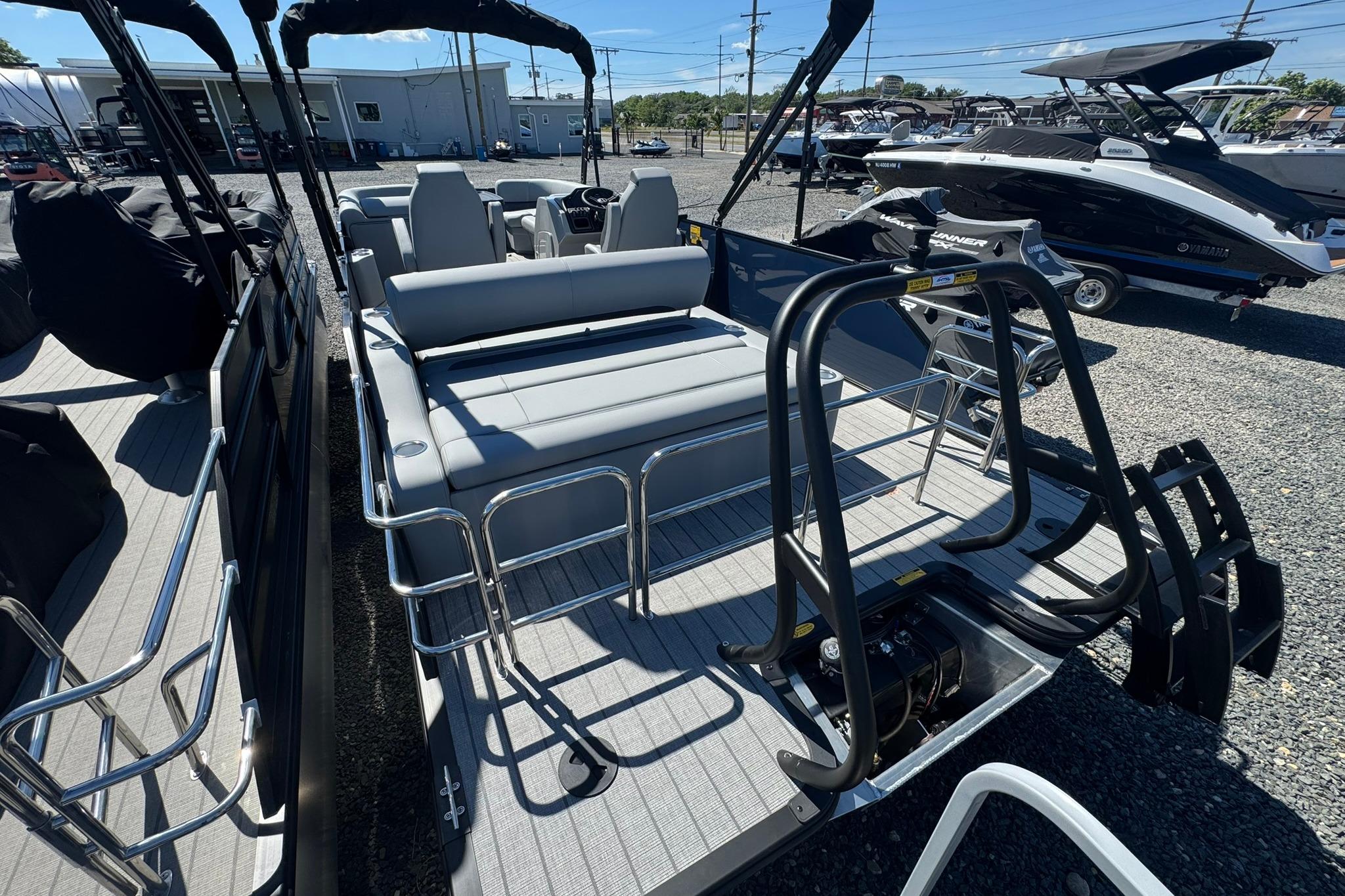 2026 Bentley Pontoons Legacy 243 Swingback with sleek seating and modern design in a boatyard.