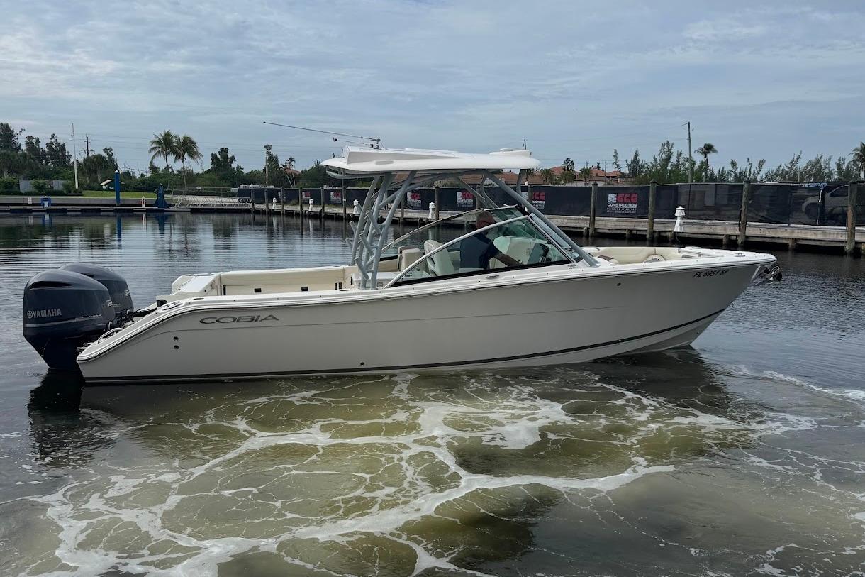 2020 Cobia 280 Dual Console boat docked in a marina, featuring Yamaha outboard engines.