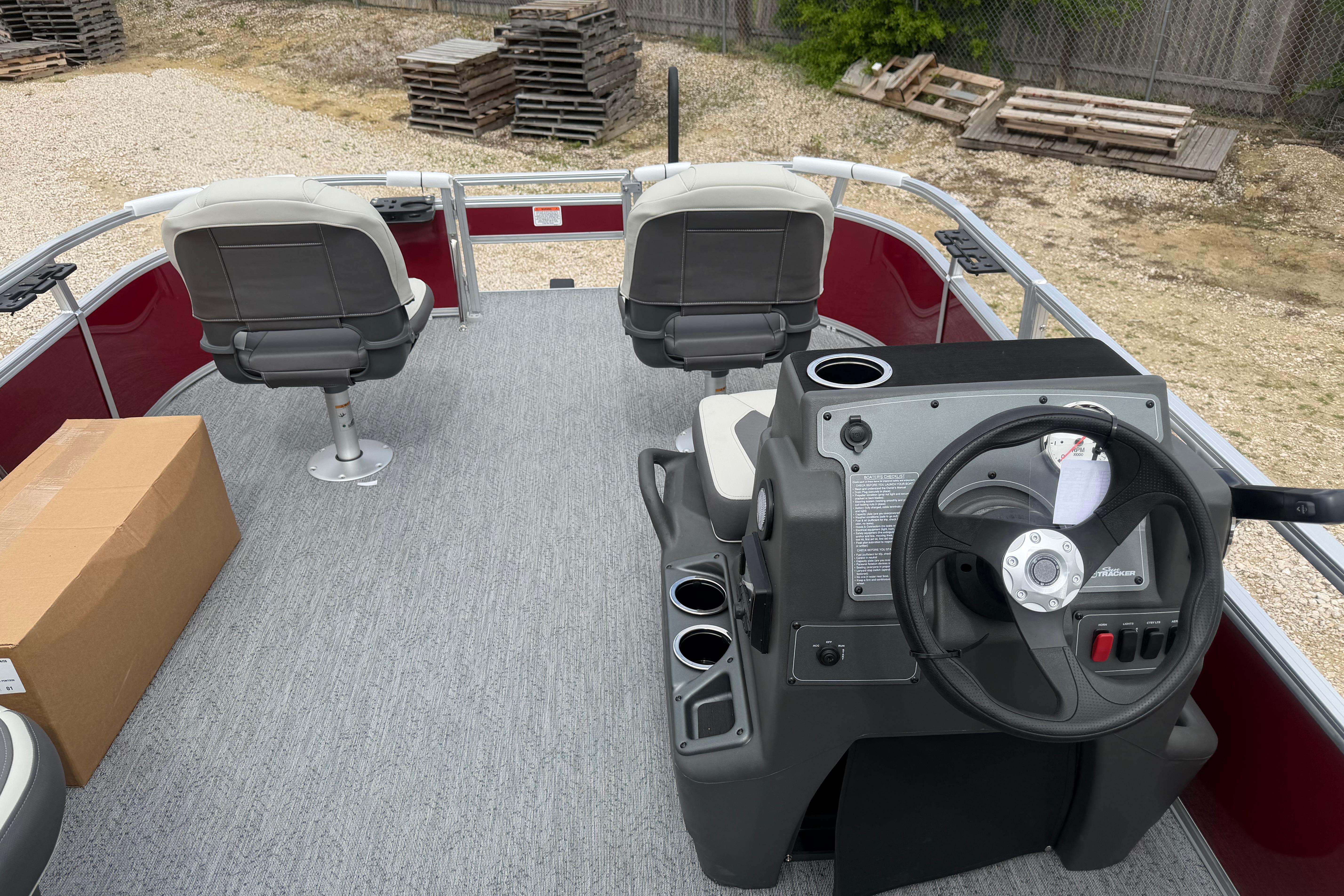 2026 Sun Tracker Bass Buggy 16 XL Select pontoon boat interior with steering console and seating.
