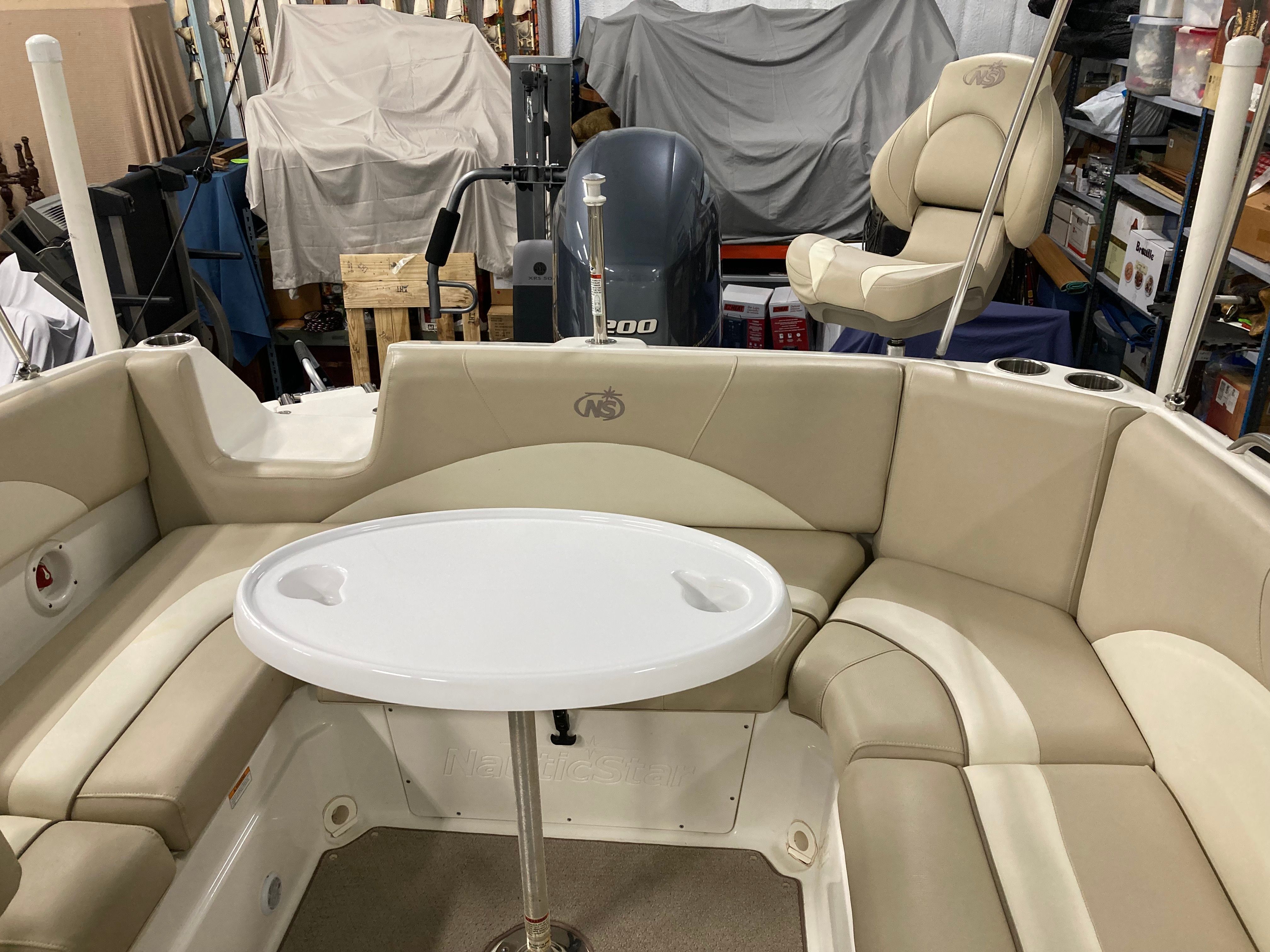 Interior of a 2016 Custom 223 DC boat with beige seating area and table.