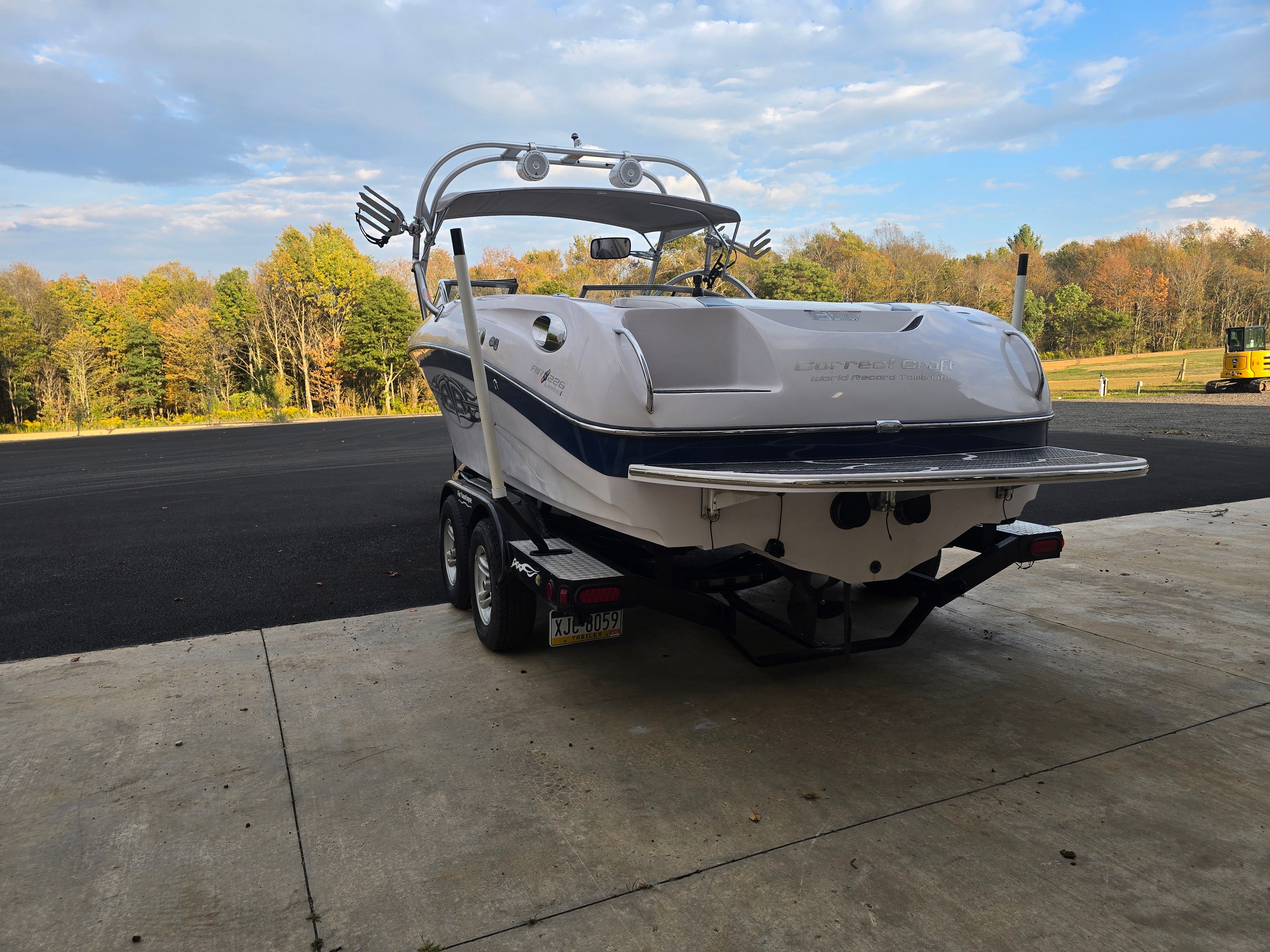 2006 Correct Craft 228 boat on trailer, autumn landscape.