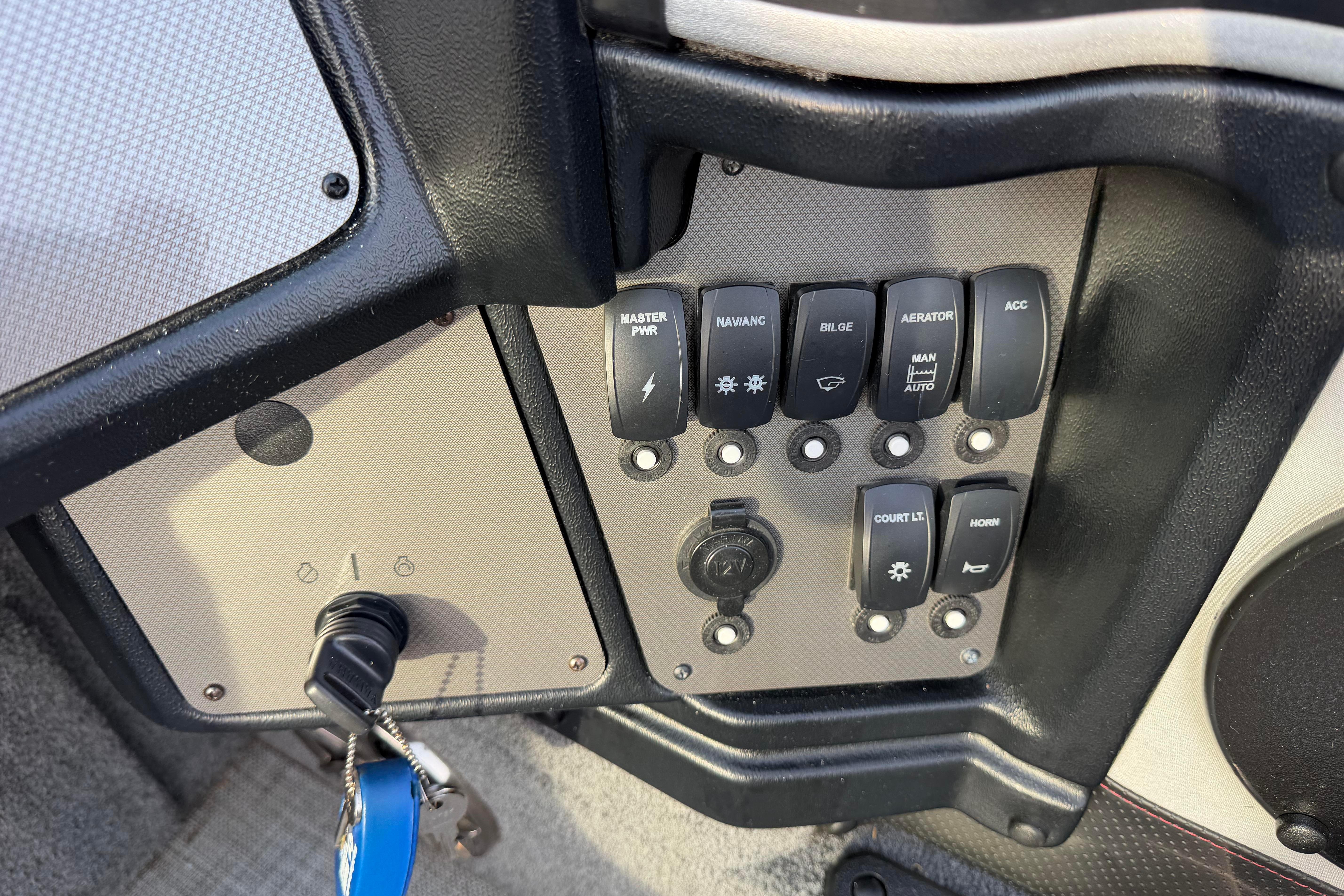 Control panel of a 2019 Alumacraft Trophy 205 boat with various switches and key ignition.