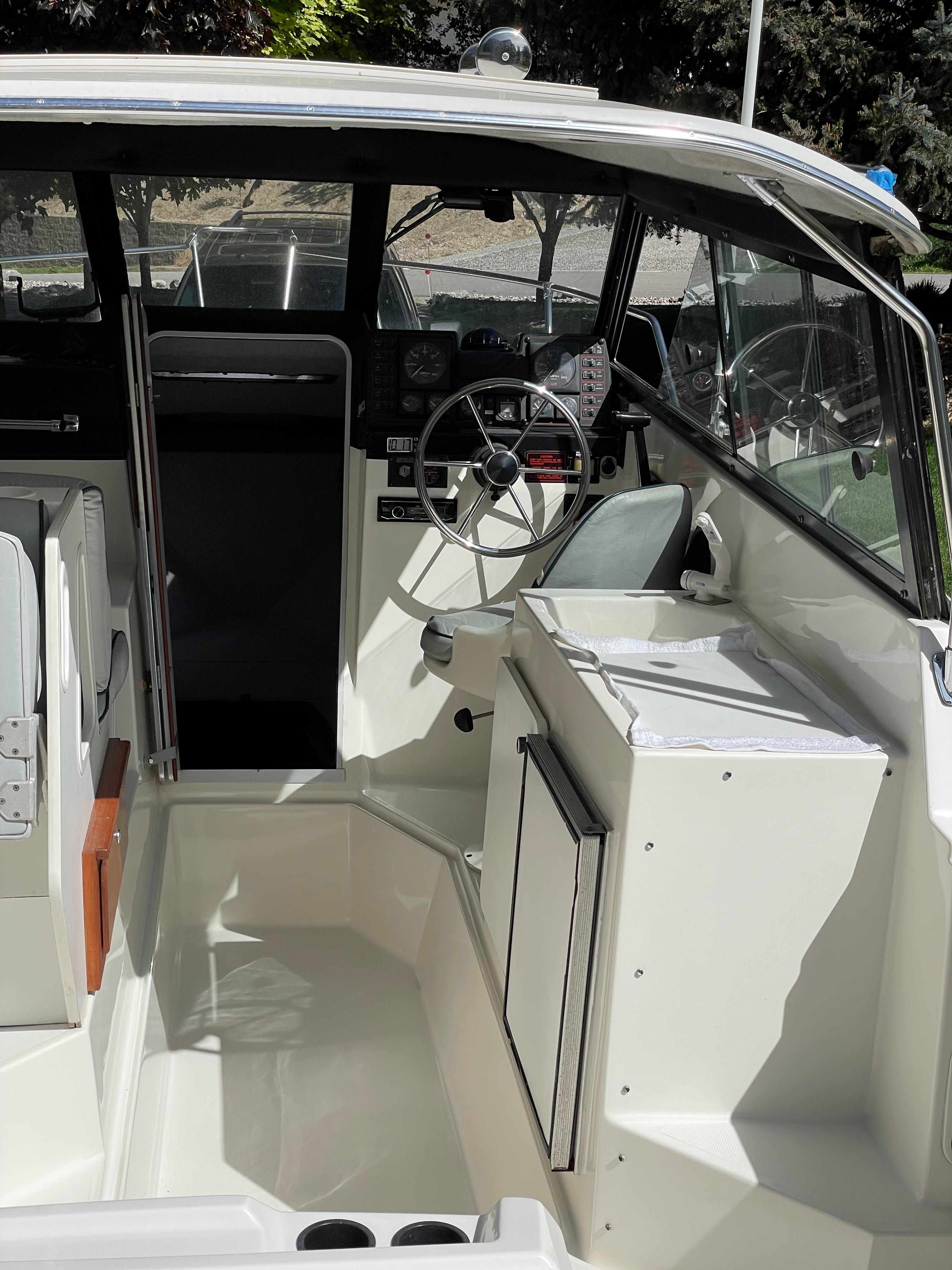 The image shows the cockpit of a 1991 Bayliner 2159 boat with helm and seating area.