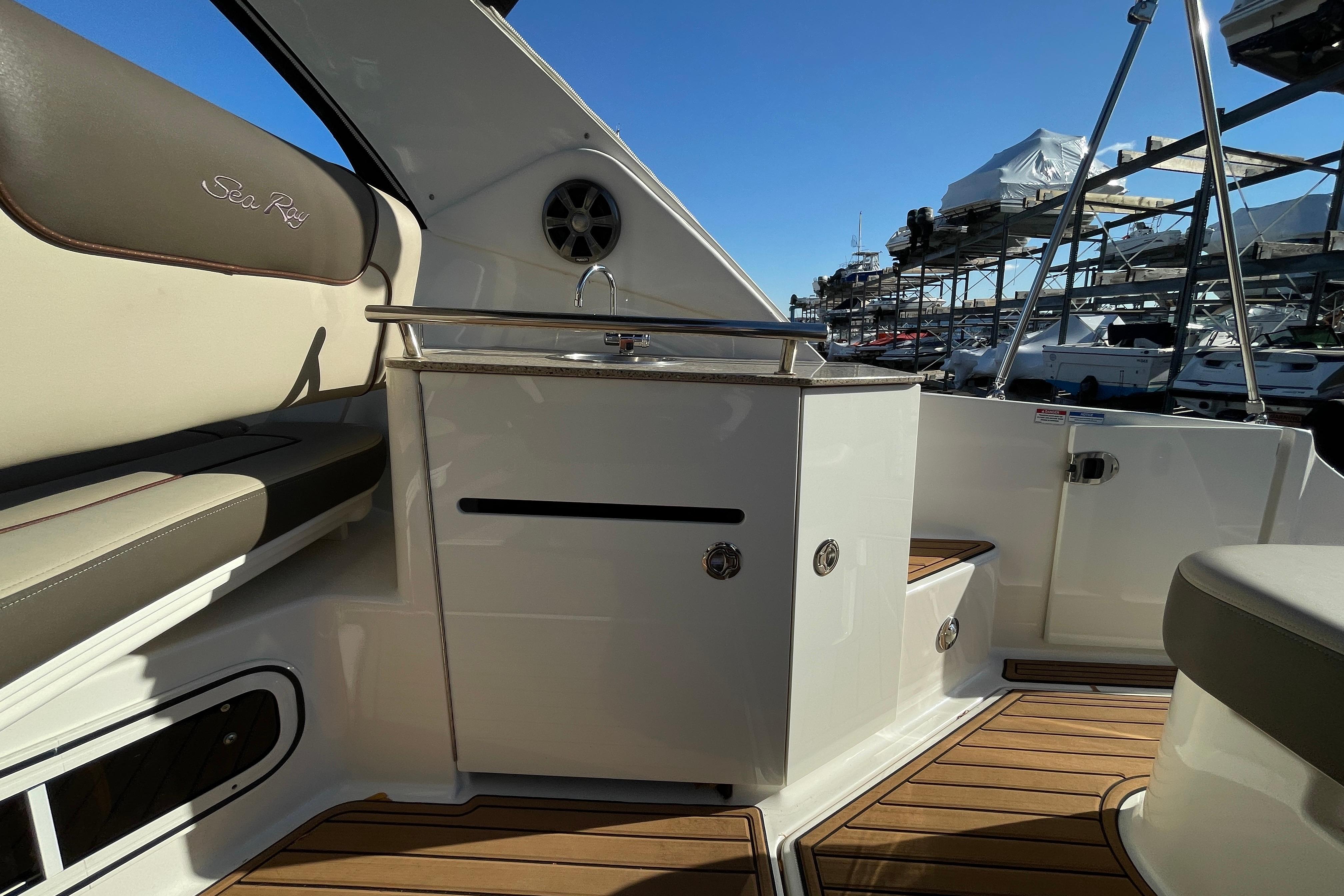 2016 Sea Ray 310 Sundancer interior with seating and kitchenette, docked at marina.