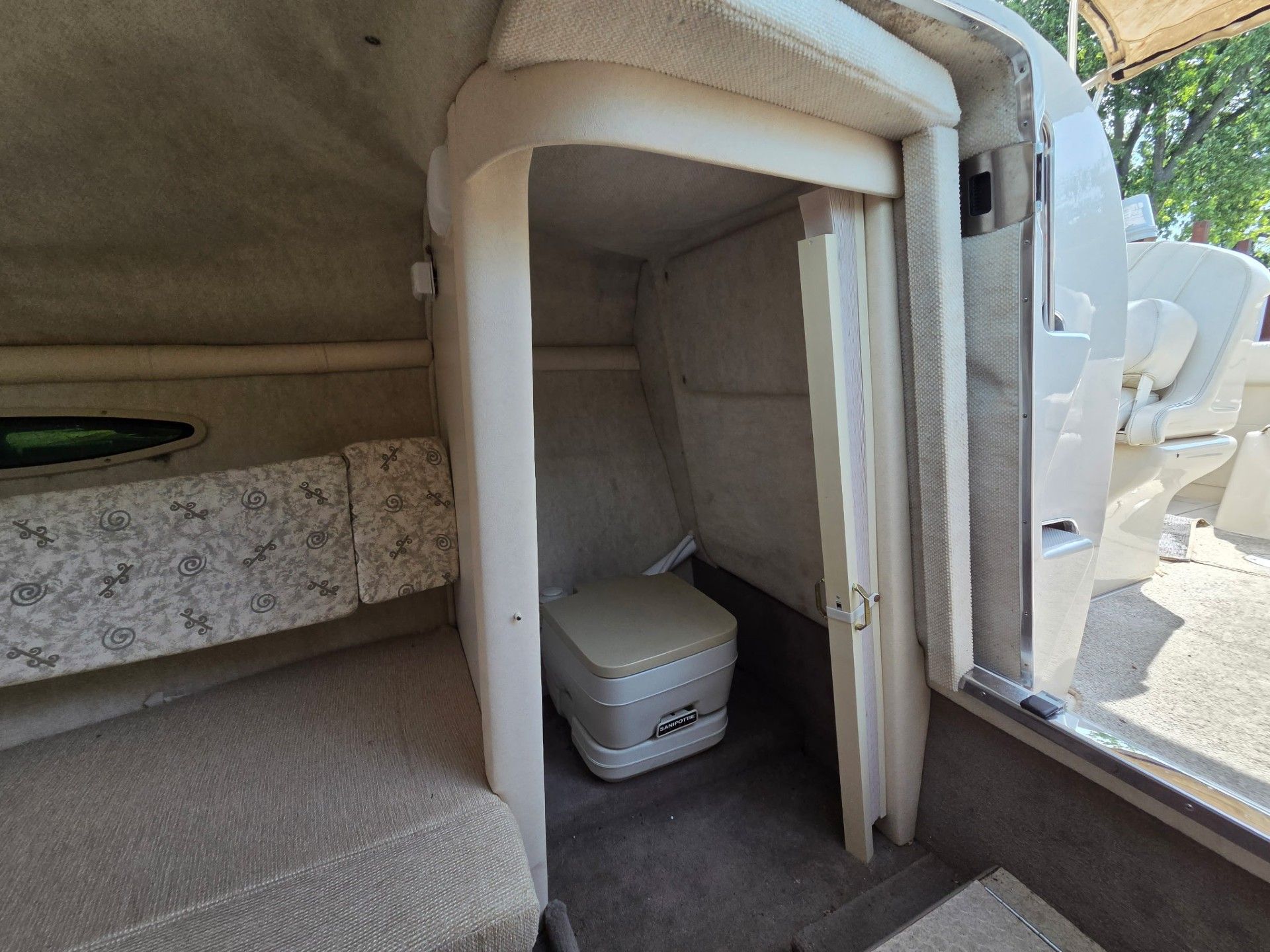 Interior of a 2002 Sea Ray 225 Weekender with a toilet and seating area.