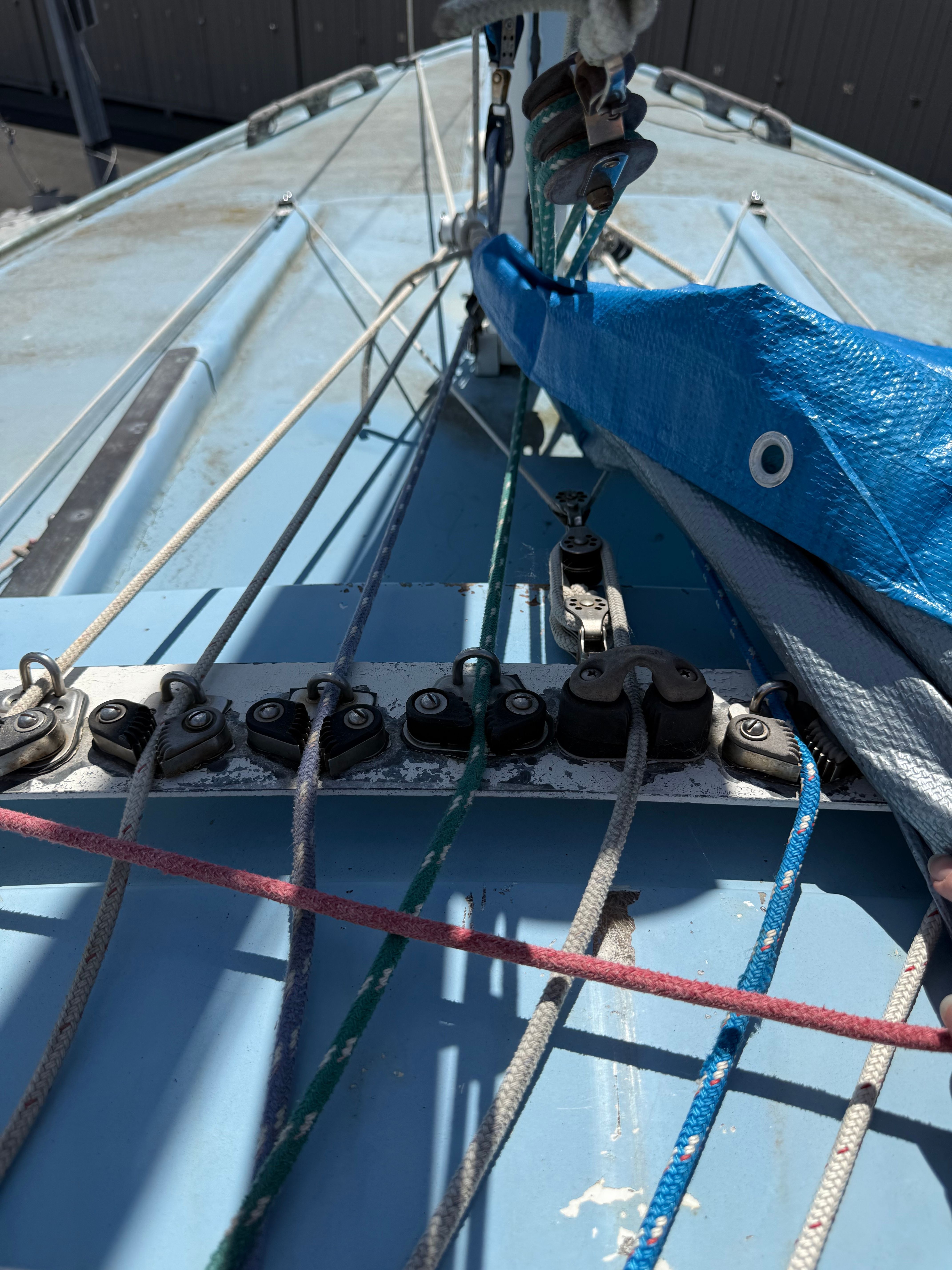 Close-up of a 1965 CAL 20 sailboat deck with various ropes and fittings.