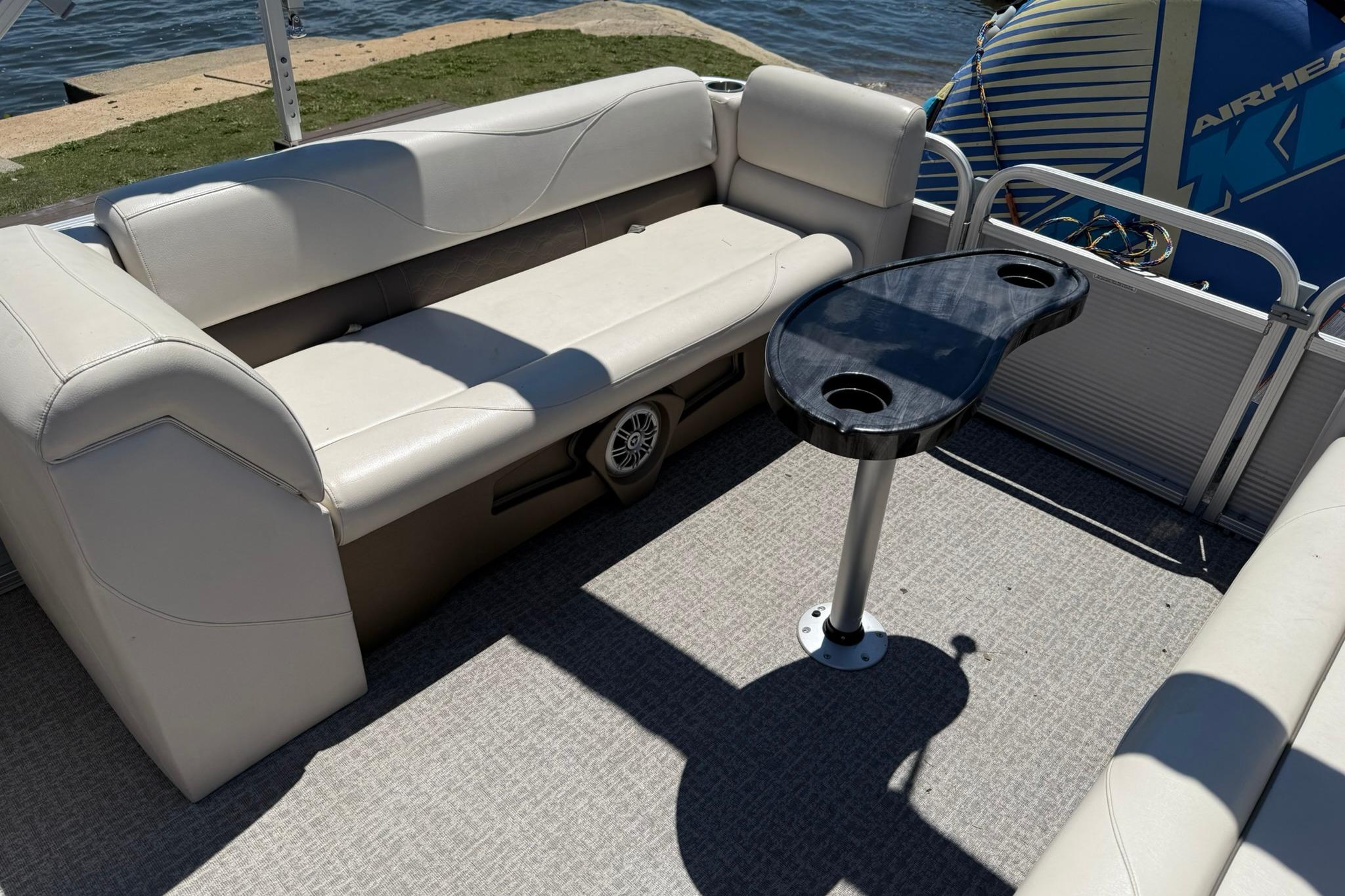 2019 Avalon GS Quad Lounge boat interior with seating and table by the water.