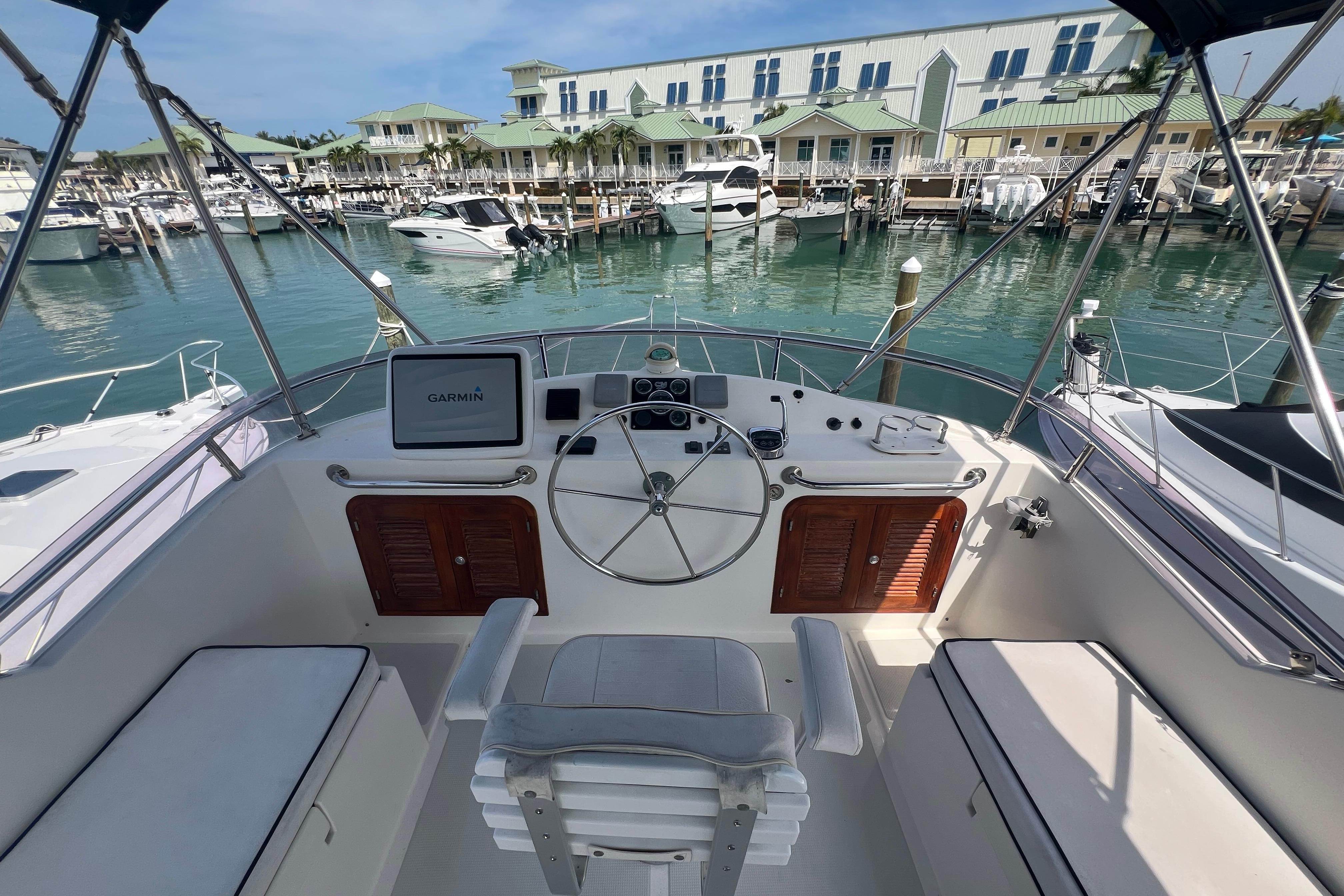 Helm of 2007 Heritage East 36 Sundeck Trawler at marina, featuring Garmin navigation system.