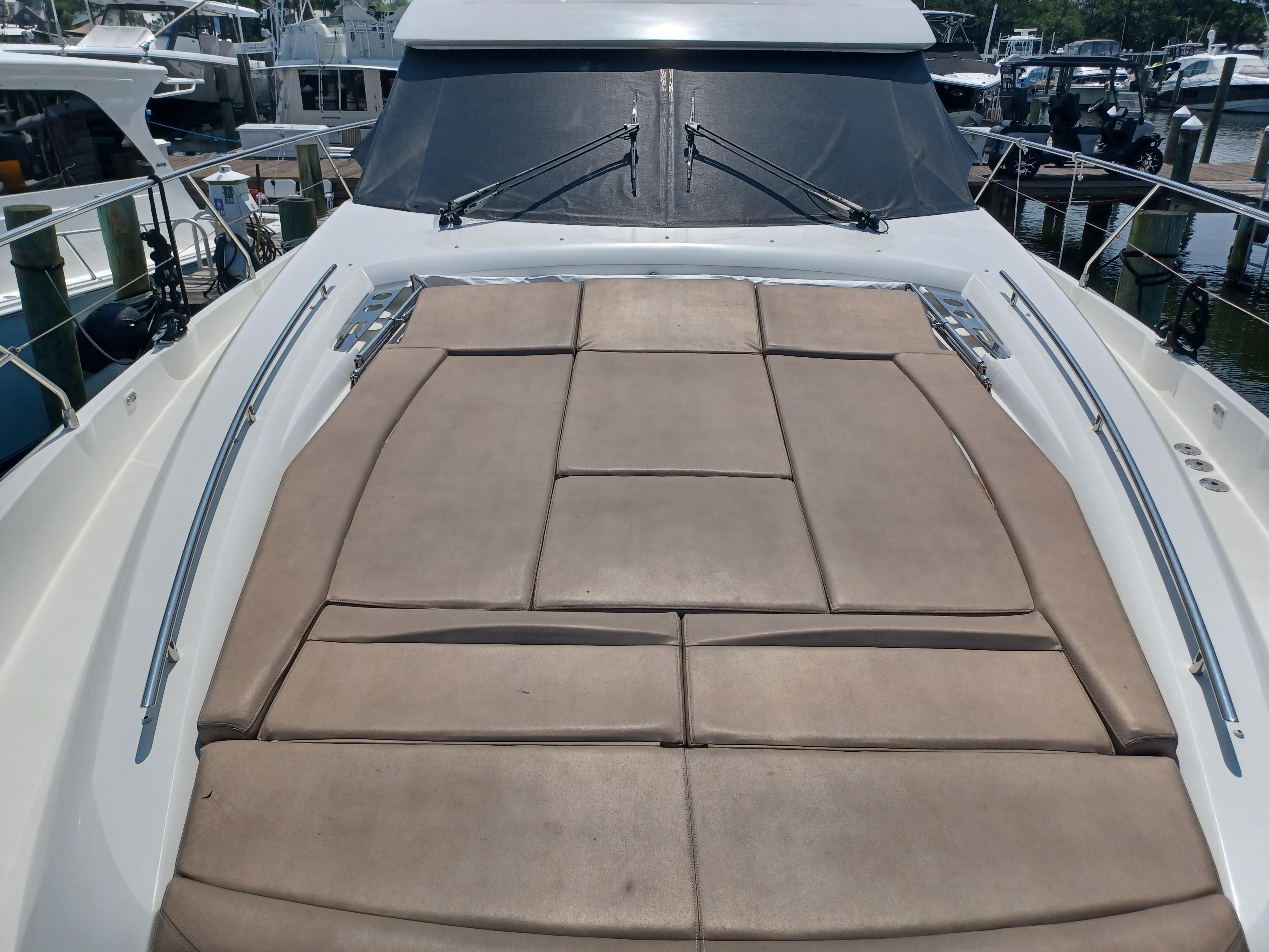 2015 Prestige 550 Flybridge yacht with spacious sunbathing deck in marina.
