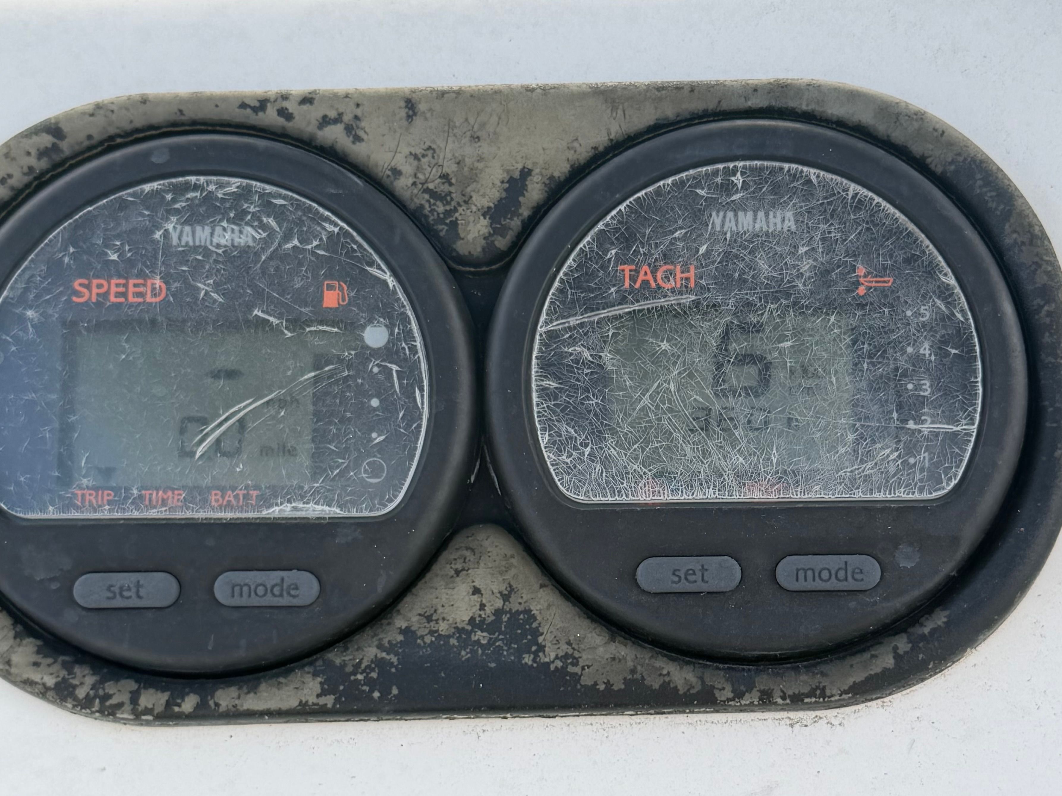 Two scratched Yamaha gauges display speed and RPM.