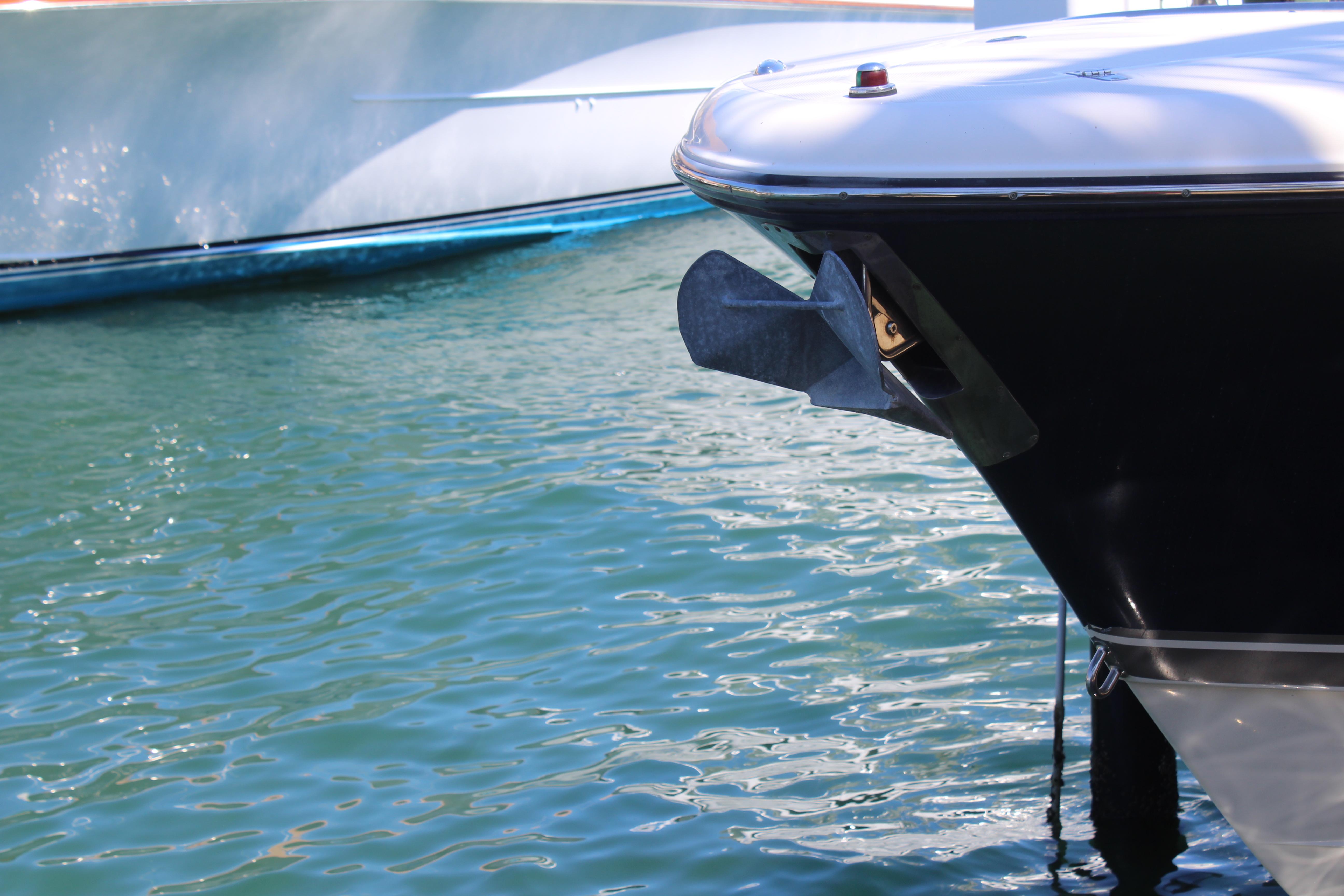 Bow of a 2008 Pursuit S 310 Sport boat with anchor, on calm water.