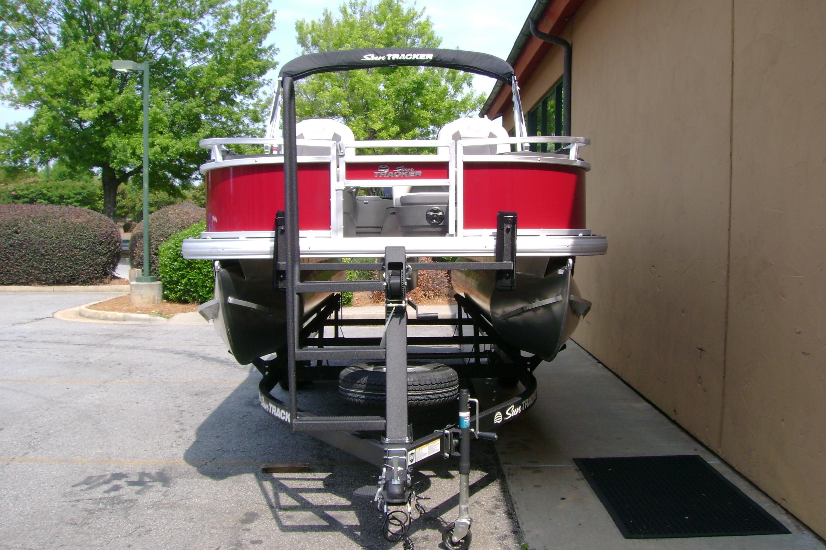 2026 Sun Tracker Bass Buggy 18 DLX pontoon boat on trailer, parked outdoors.