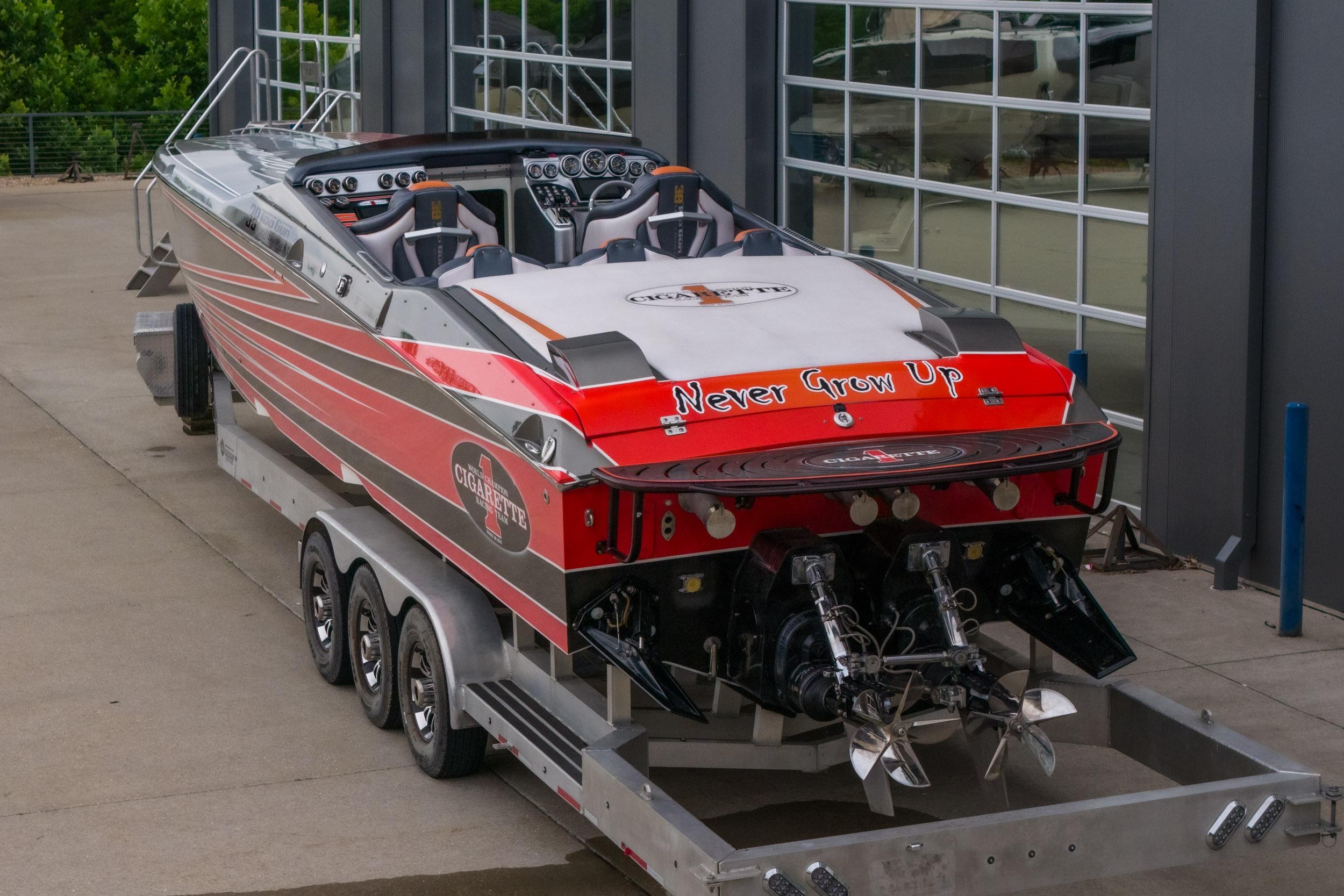 2006 Cigarette 39' Top Gun Unlimited speedboat on trailer, featuring "Never Grow Up" text.