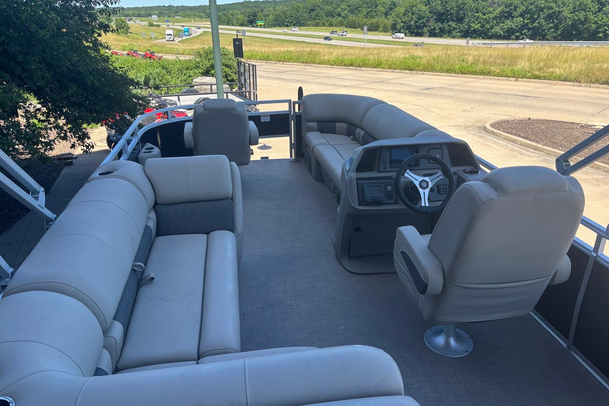 2025 Sun Tracker SportFish 20 DLX pontoon boat interior with plush seating and steering console.