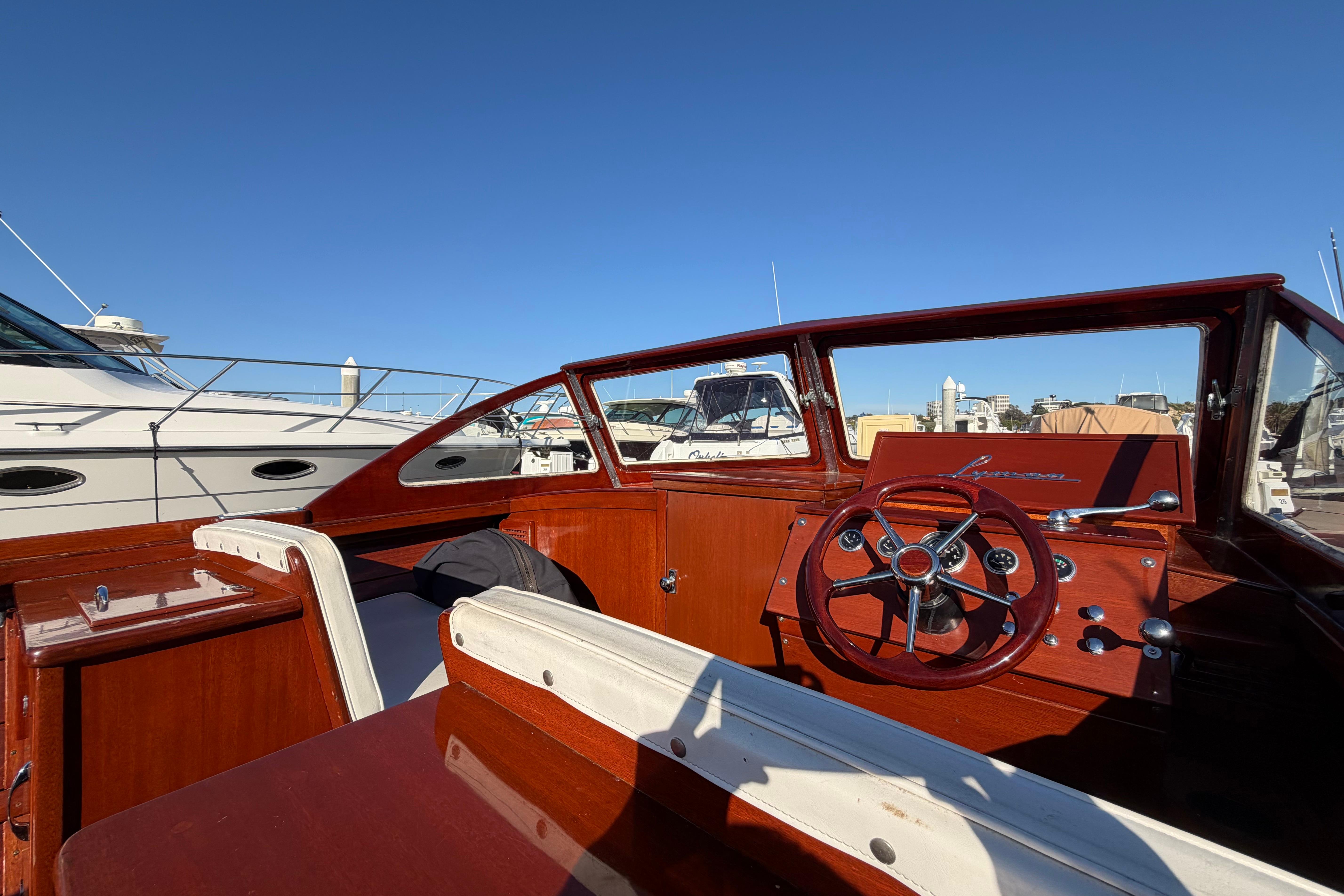 1964 Lyman 25 Sleeper boat interior with wooden dashboard and steering wheel.