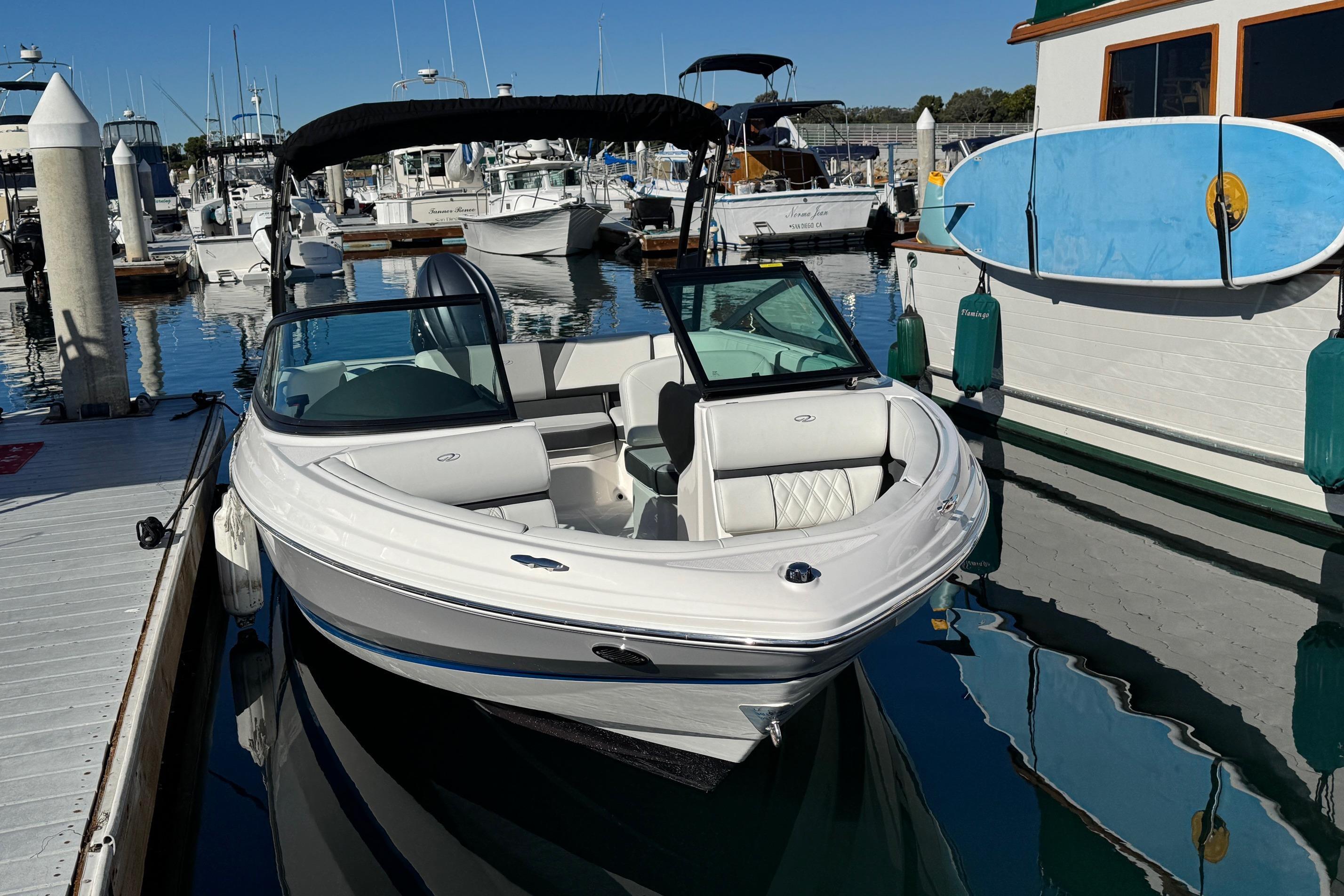 2026 Regal 21 OBX boat docked at marina with paddleboard nearby.