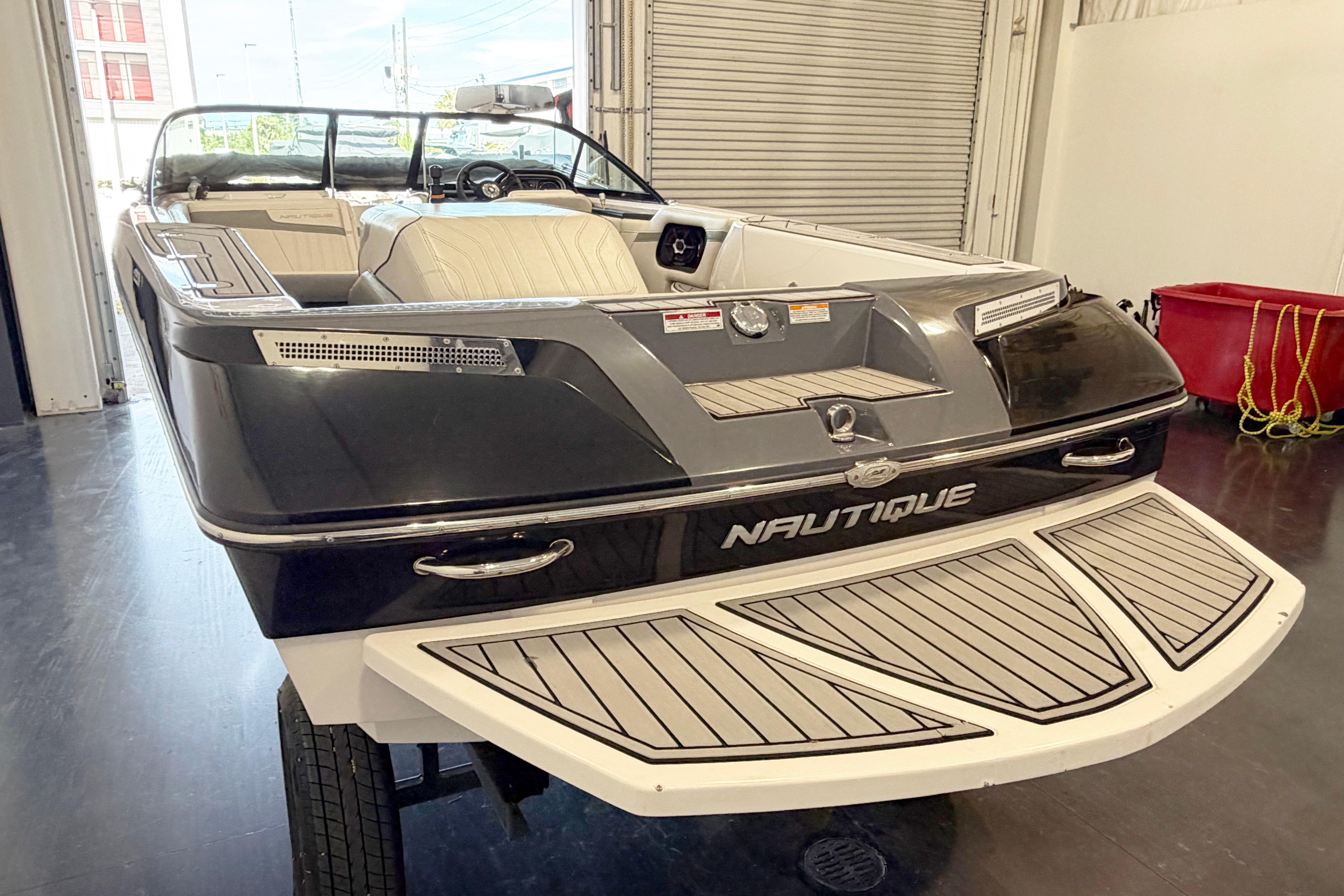 2014 Nautique Ski Nautique 200 Open Bow boat in a showroom, showcasing sleek design.