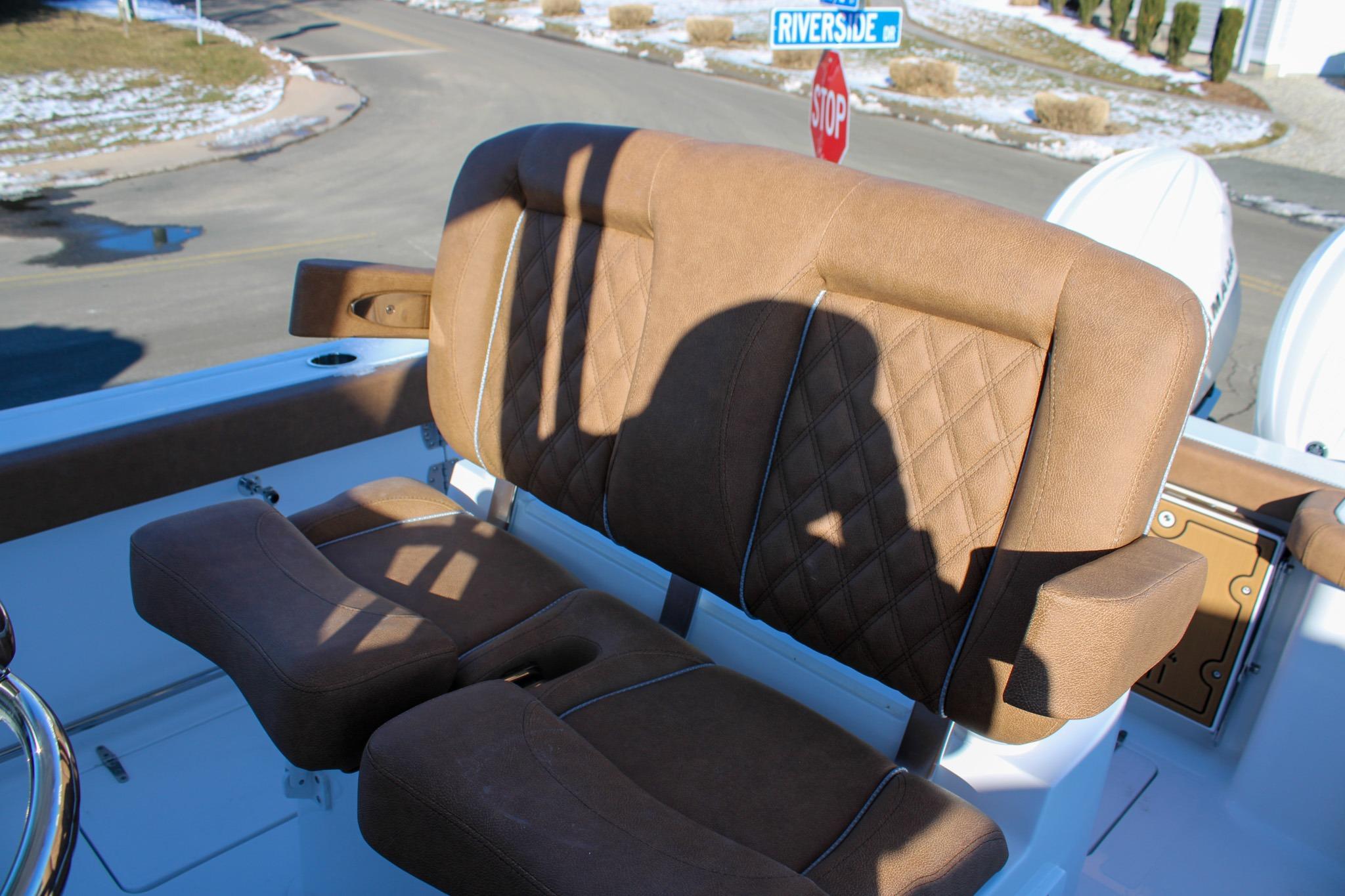 Brown leather seating on 2026 Sea Hunt Gamefish 25 boat, with shadow and street signs visible.