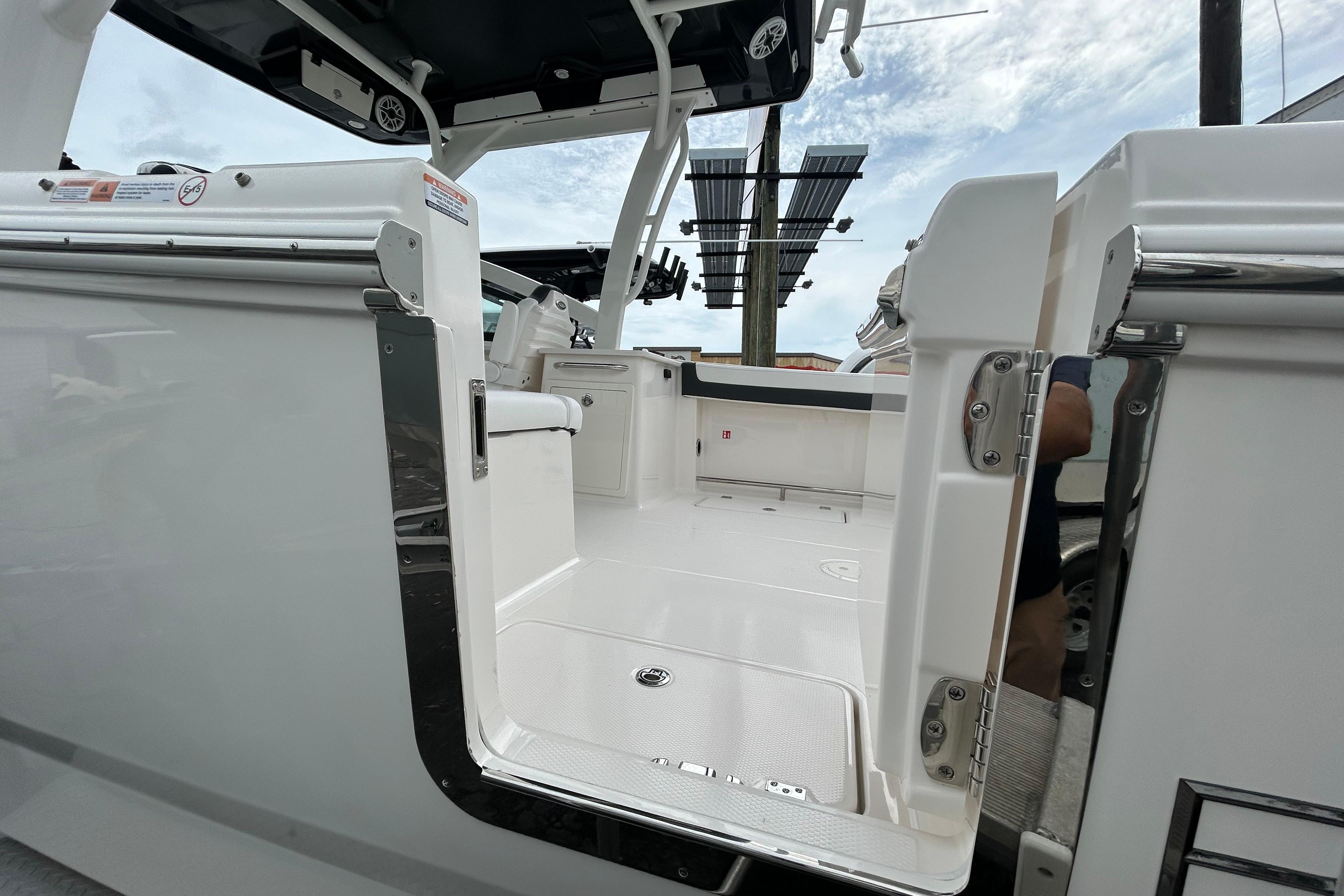 2026 Robalo R257 Dual Console boat interior with open door and seating area.