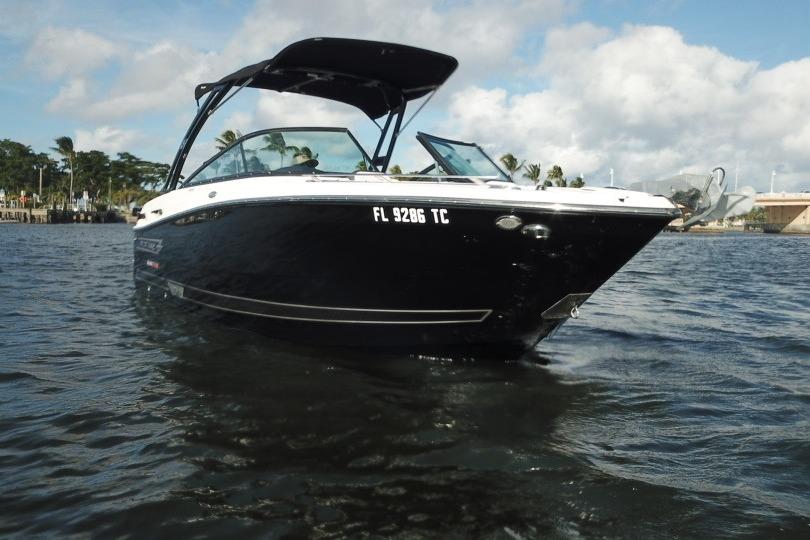 2022 Monterey 255SS Super Sport boat on water, black hull, sunny day.